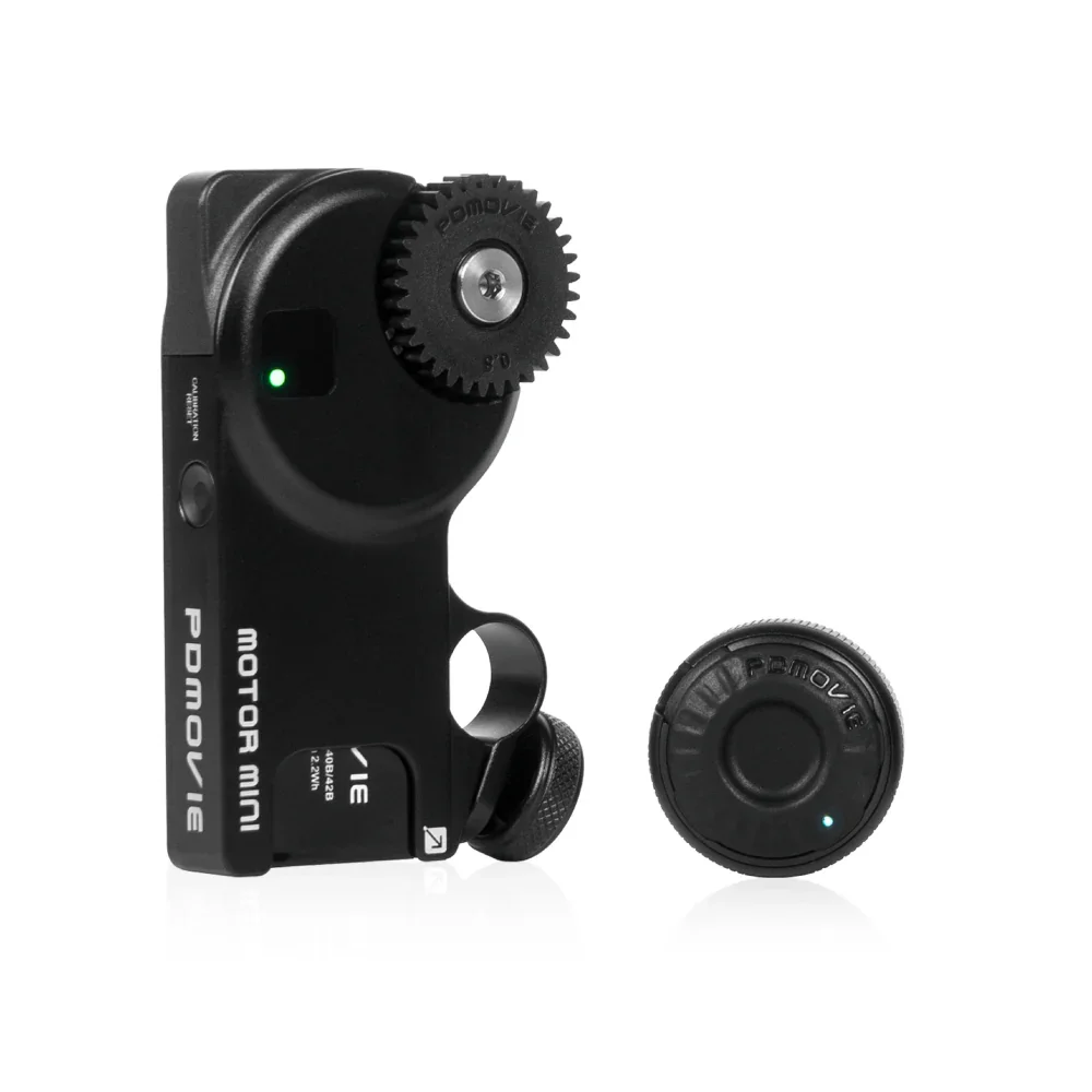A black motorized camera control device with a wheel and brain-themed buttons, positioned next to a round camera component with a small green indicator light.