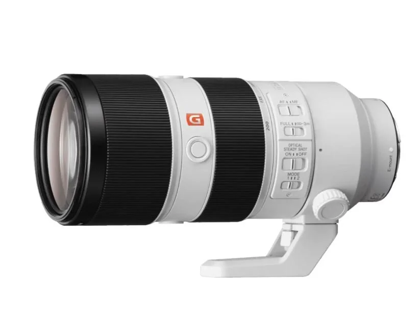 A professional telephoto camera lens with various settings on the side and a white tripod mount.