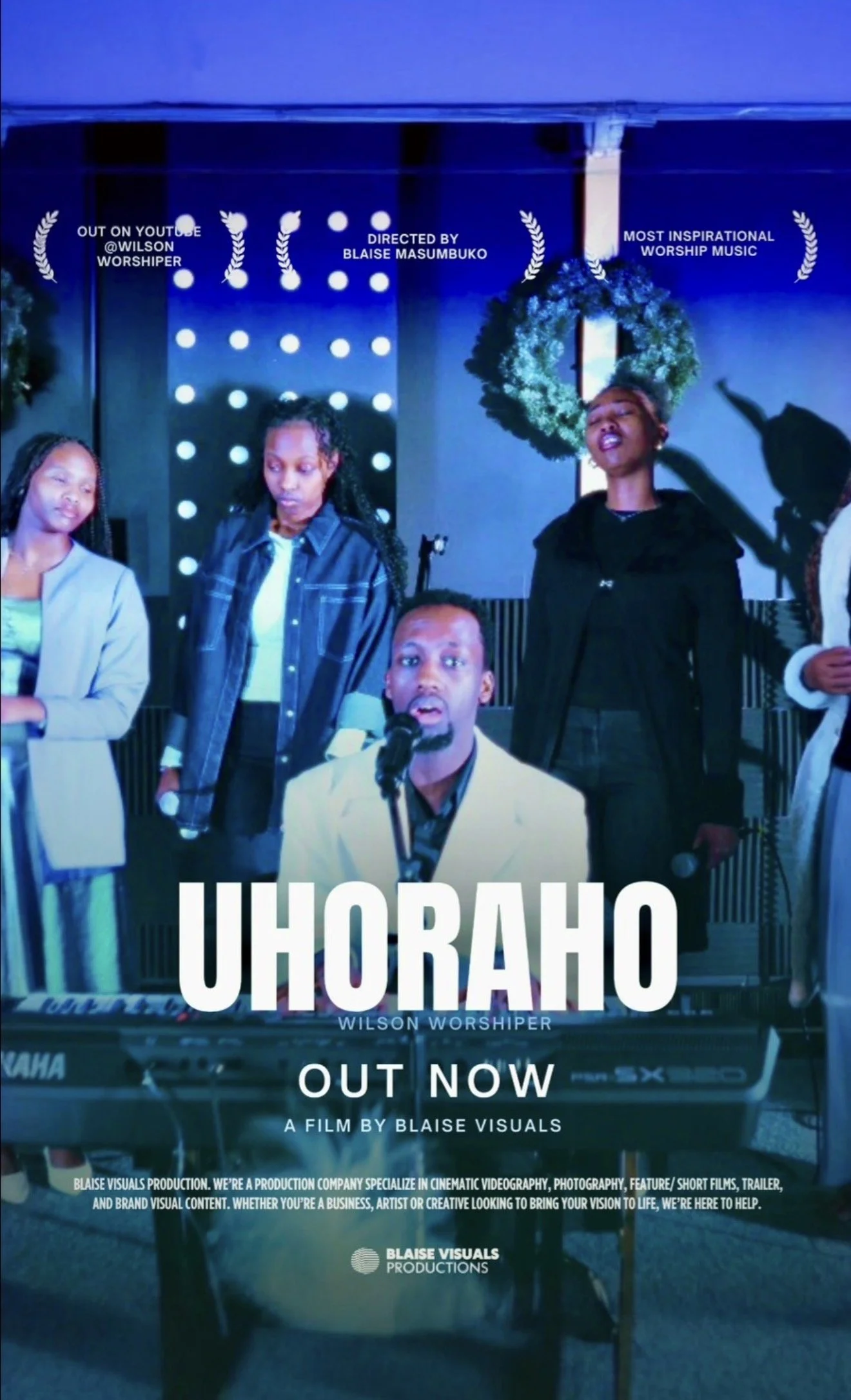 Promotional poster for a film titled 'UHORAHO' by Wilson Worshiper, directed by Blaise Masumbuko, now available. The poster features the director singing into a microphone, with two women and a keyboard in the background, decorated with a wreath and 