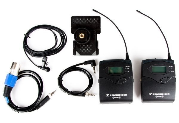 Audio wireless microphone system components including two transmitters, a receiver, antennas, and connecting cables.