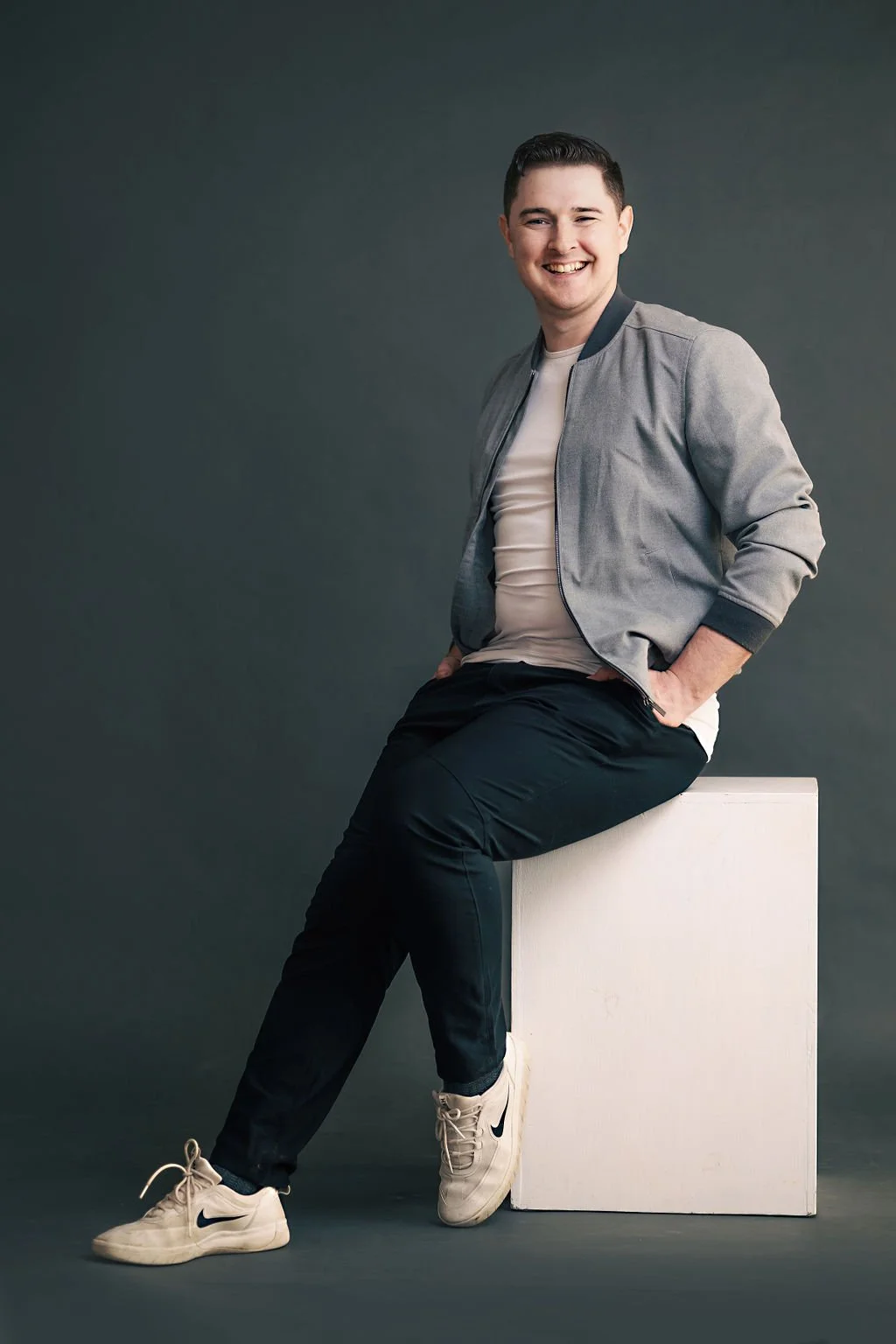 Man sits on applebox, smiling