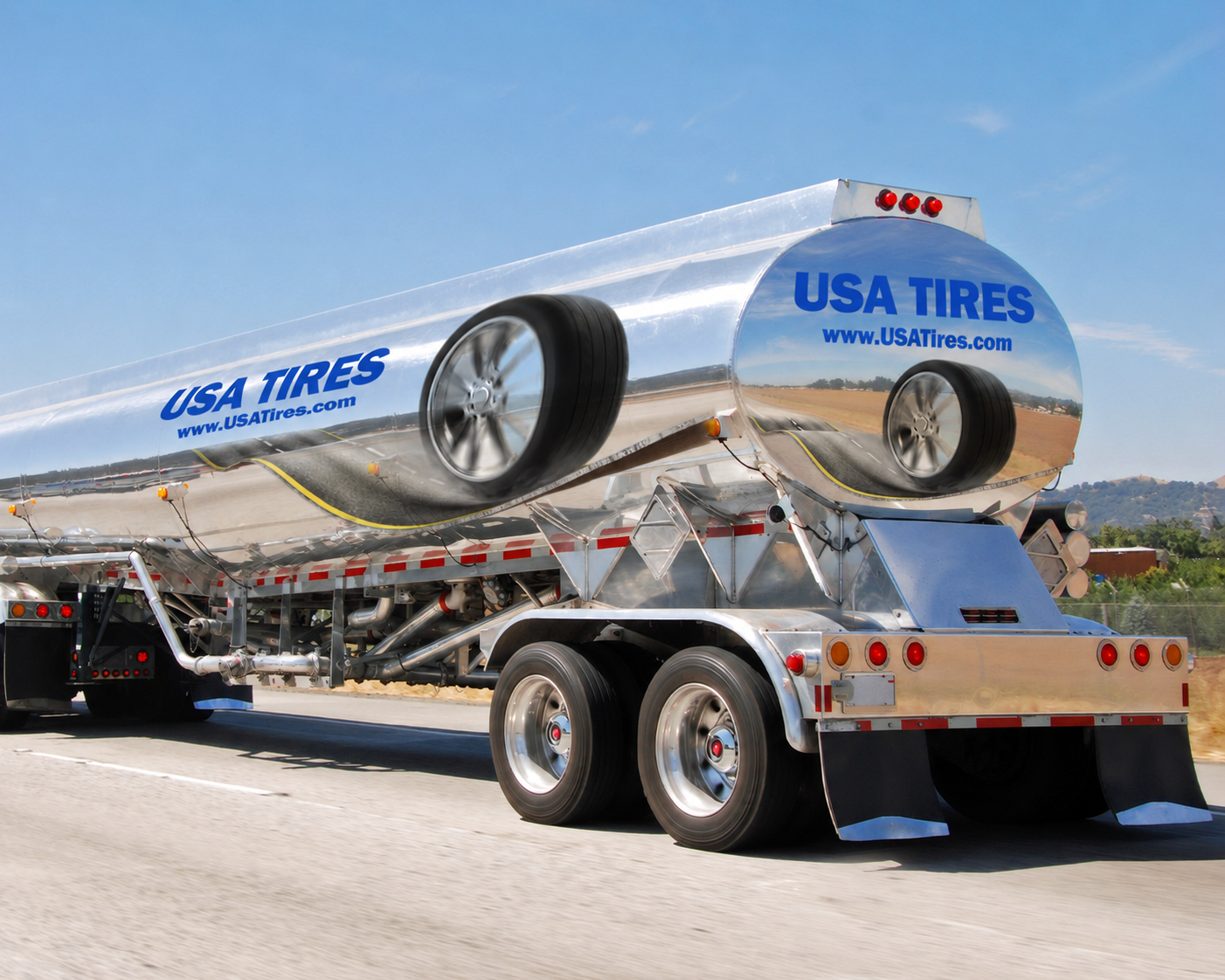 A large tanker truck with a shiny metallic finish driving on a highway. It has 'USA TIRES' and 'www.USATires.com' written on the tank. The truck is traveling on a clear day with a blue sky. Long routes, more visibility. 
