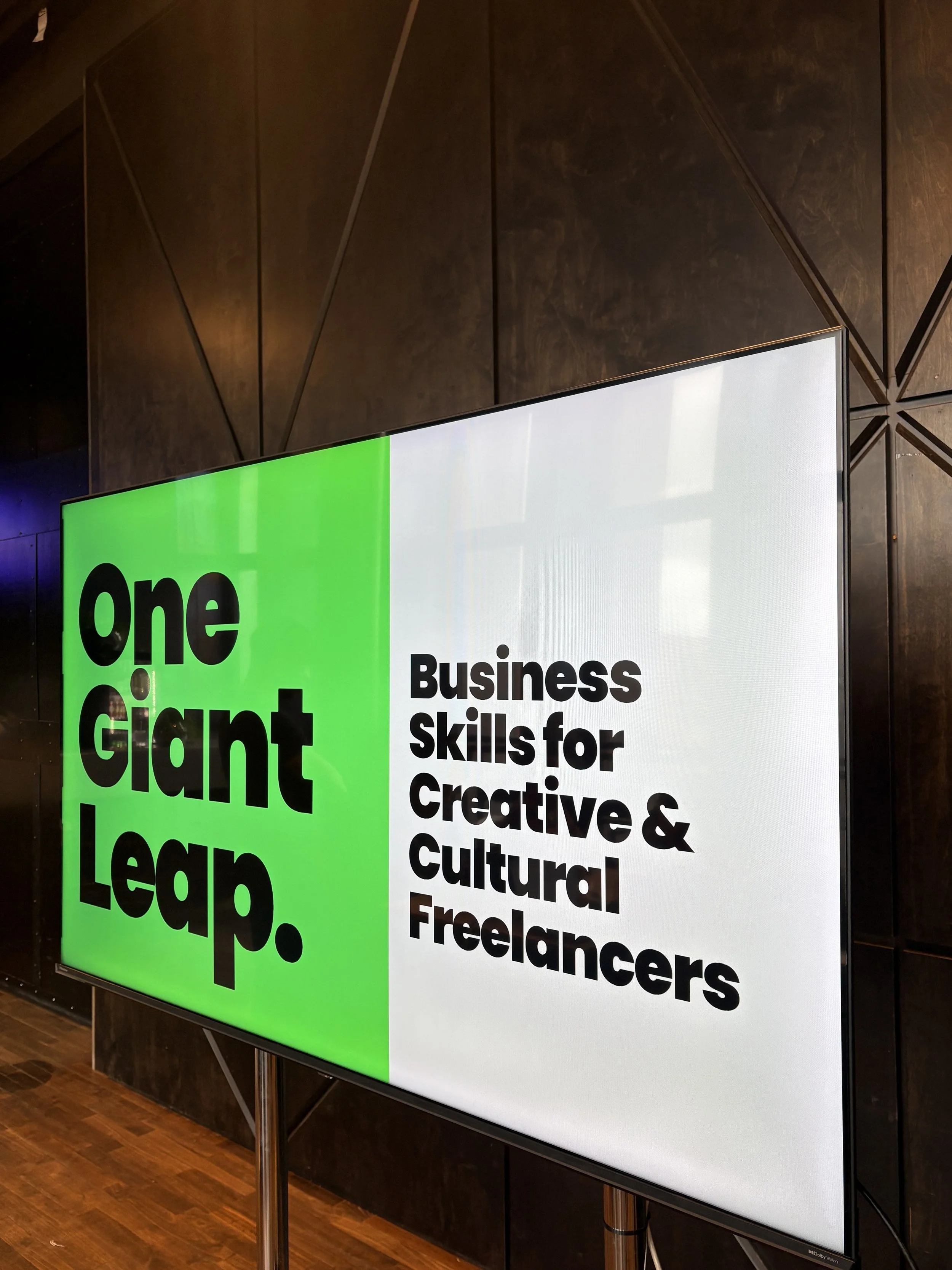 Brand identity work and key brand messaging shown on large presentation screen at live event.