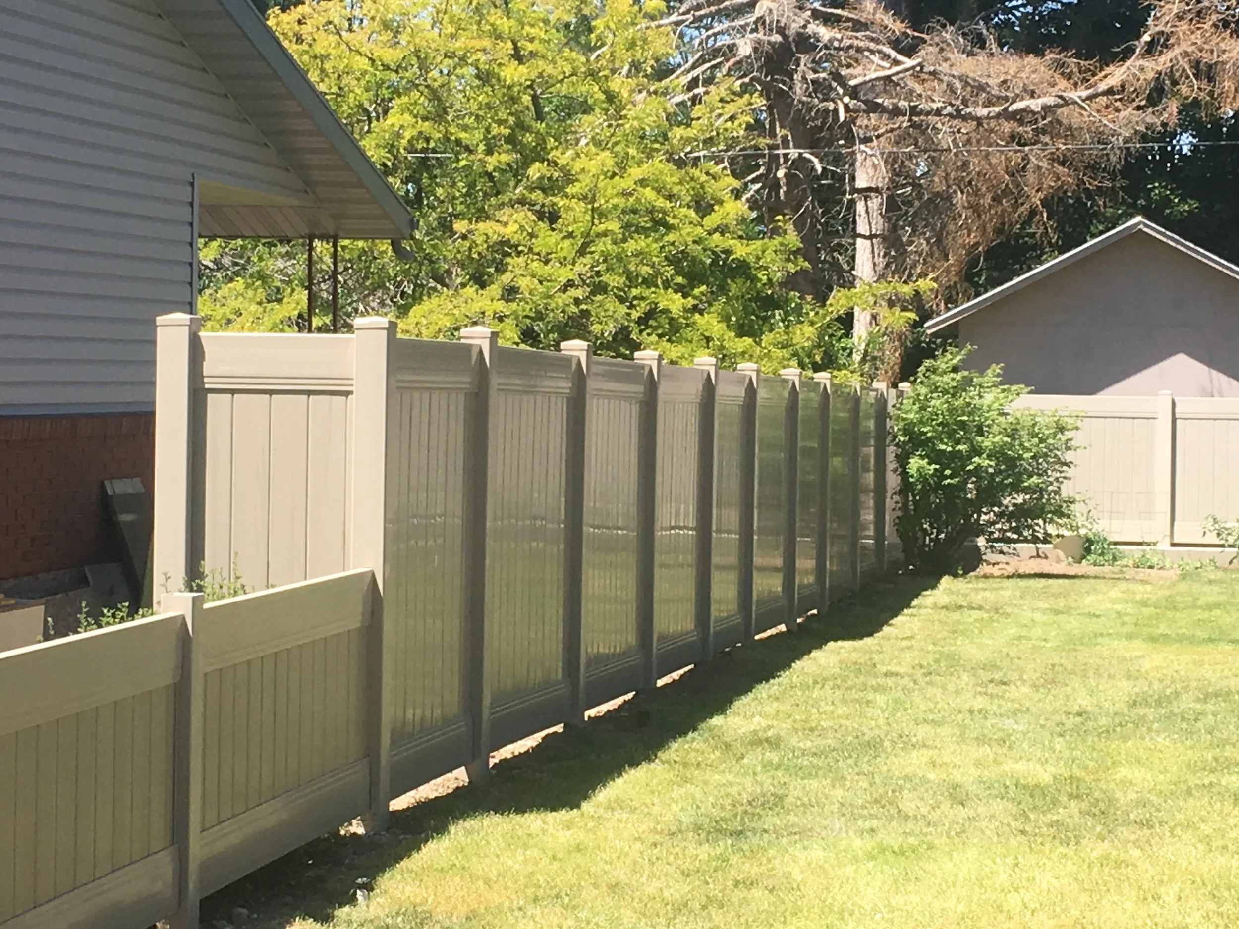 Custom adobe vinyl fence surrounding yard.
