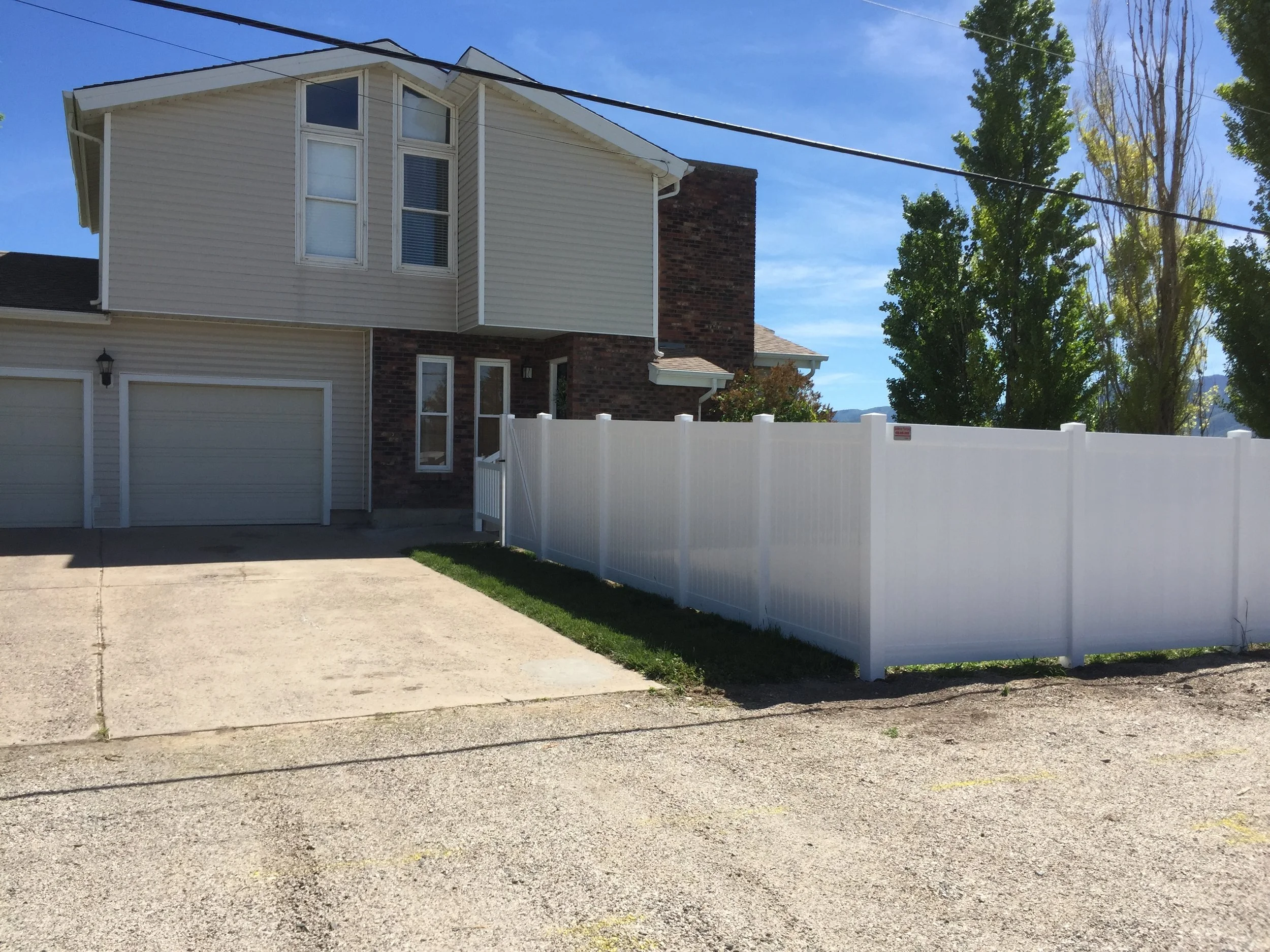 White vinyl fence in front yard of residential house done by Sublime Fencing.