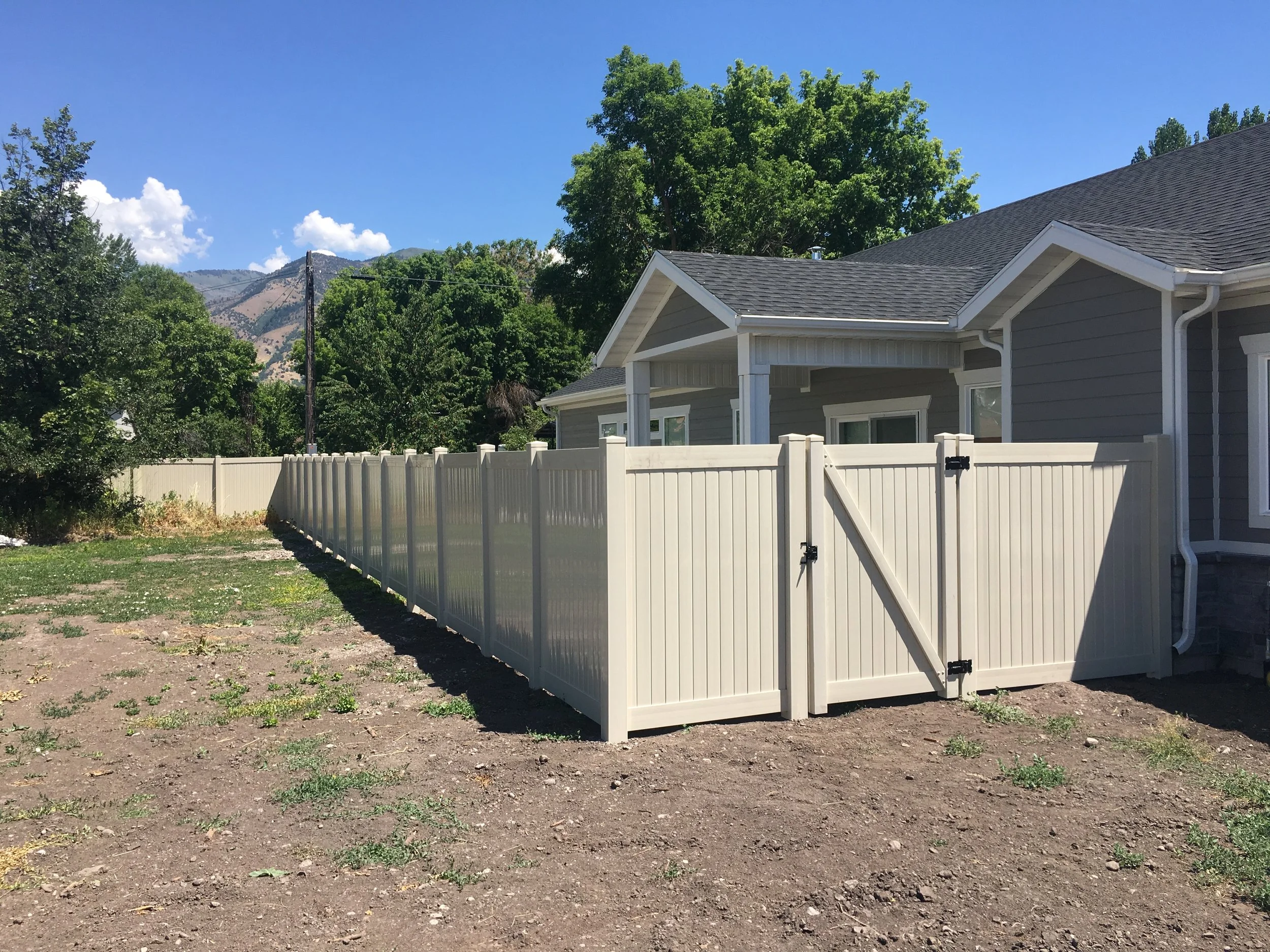 Tan vinyl fence and gate on residential property in Logan, UT.