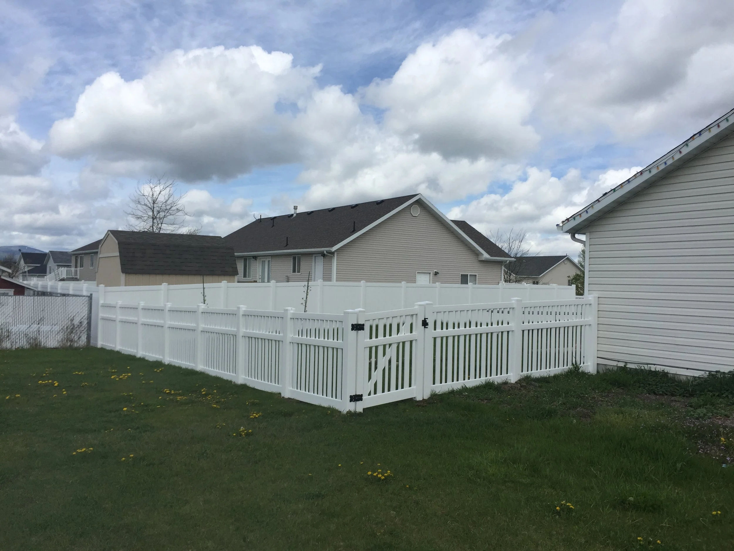 White picket vinyl fence enclosing a property in Southern ID.