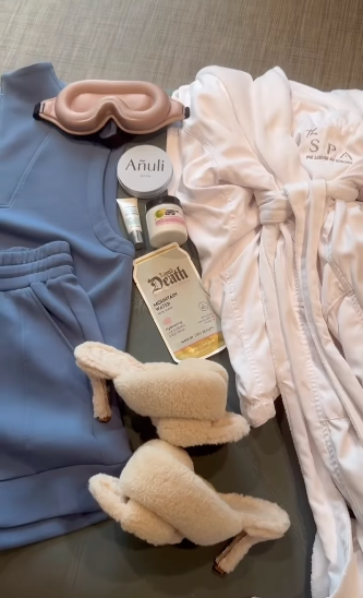 Spa and relaxation items including a blue robe, pink sleep mask, white slippers, skincare products, and a white bathrobe.