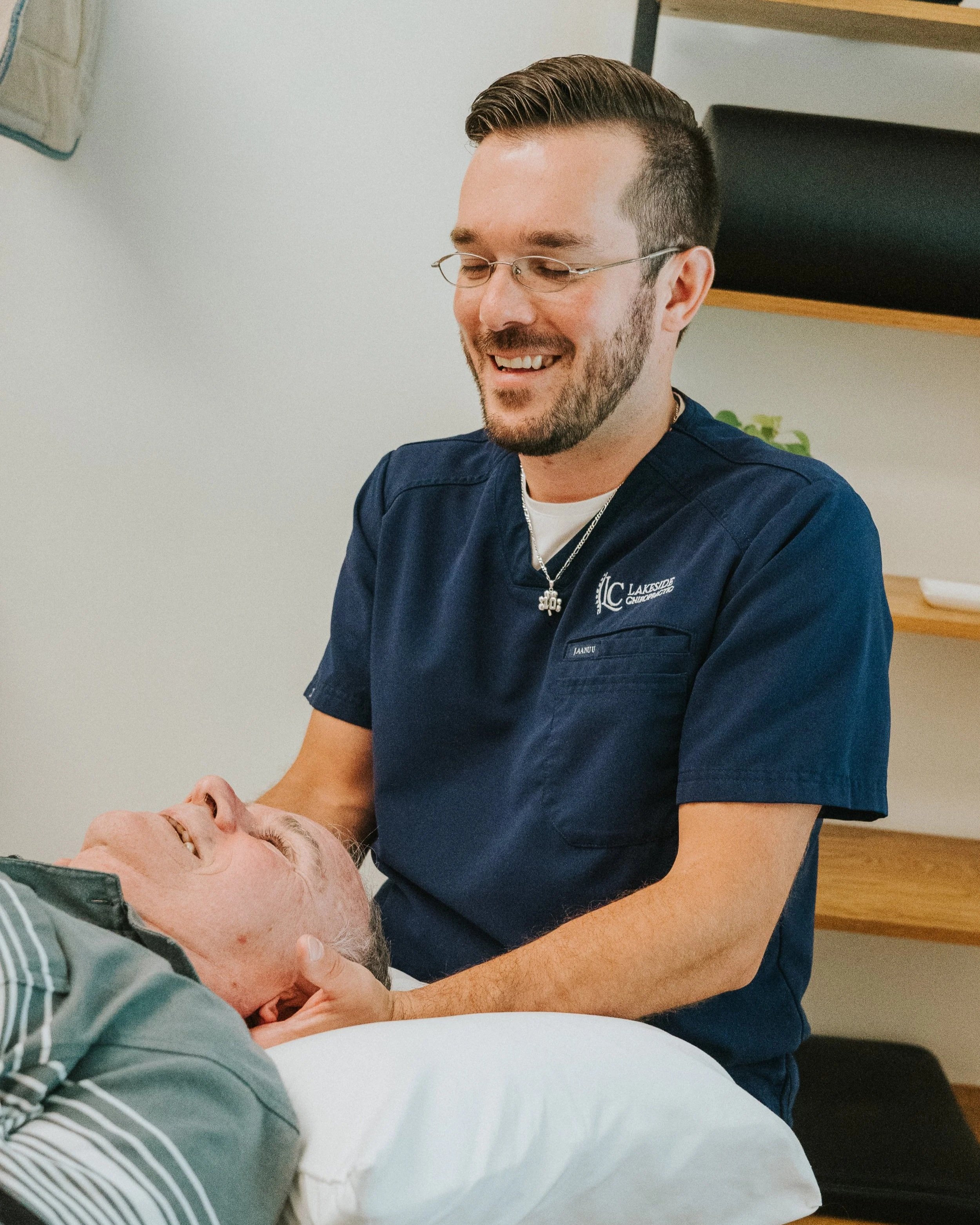 Dr. Swinton adjusting a patient and smiling