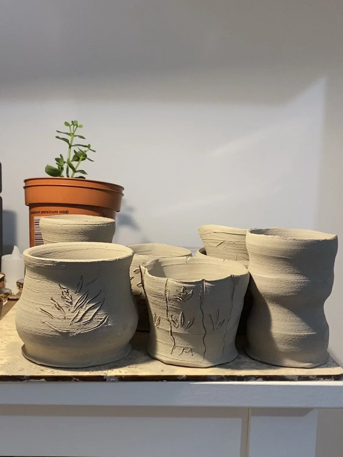 Small mugs, laced with my signature patterns and wheel-thrown in whimsical forms. To be fired soon.