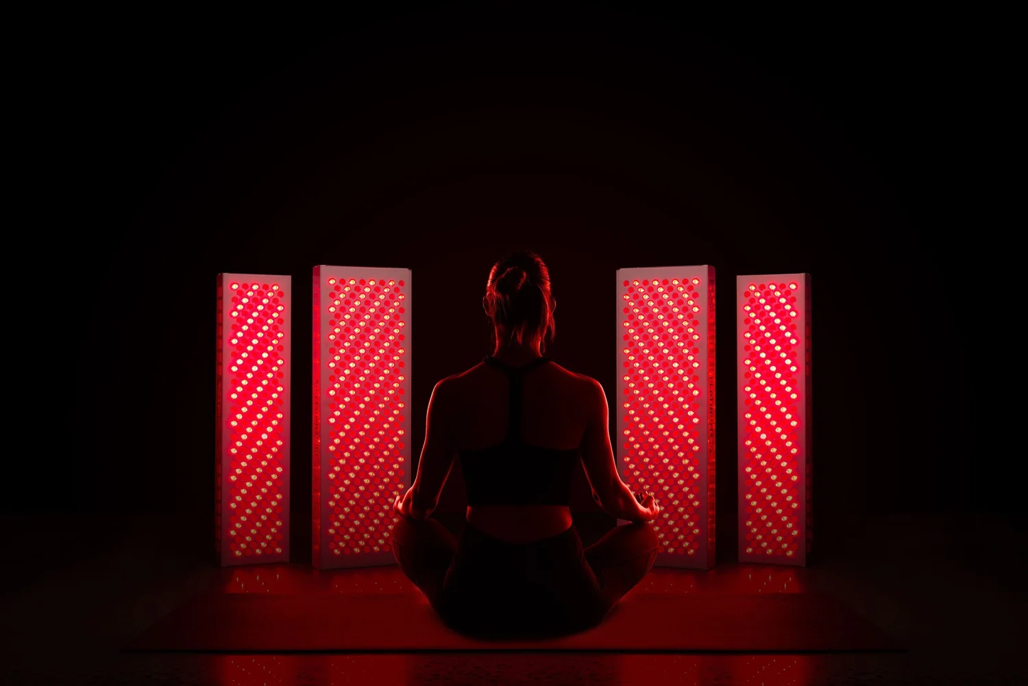 Woman seated in front of red and near-infrared light panels