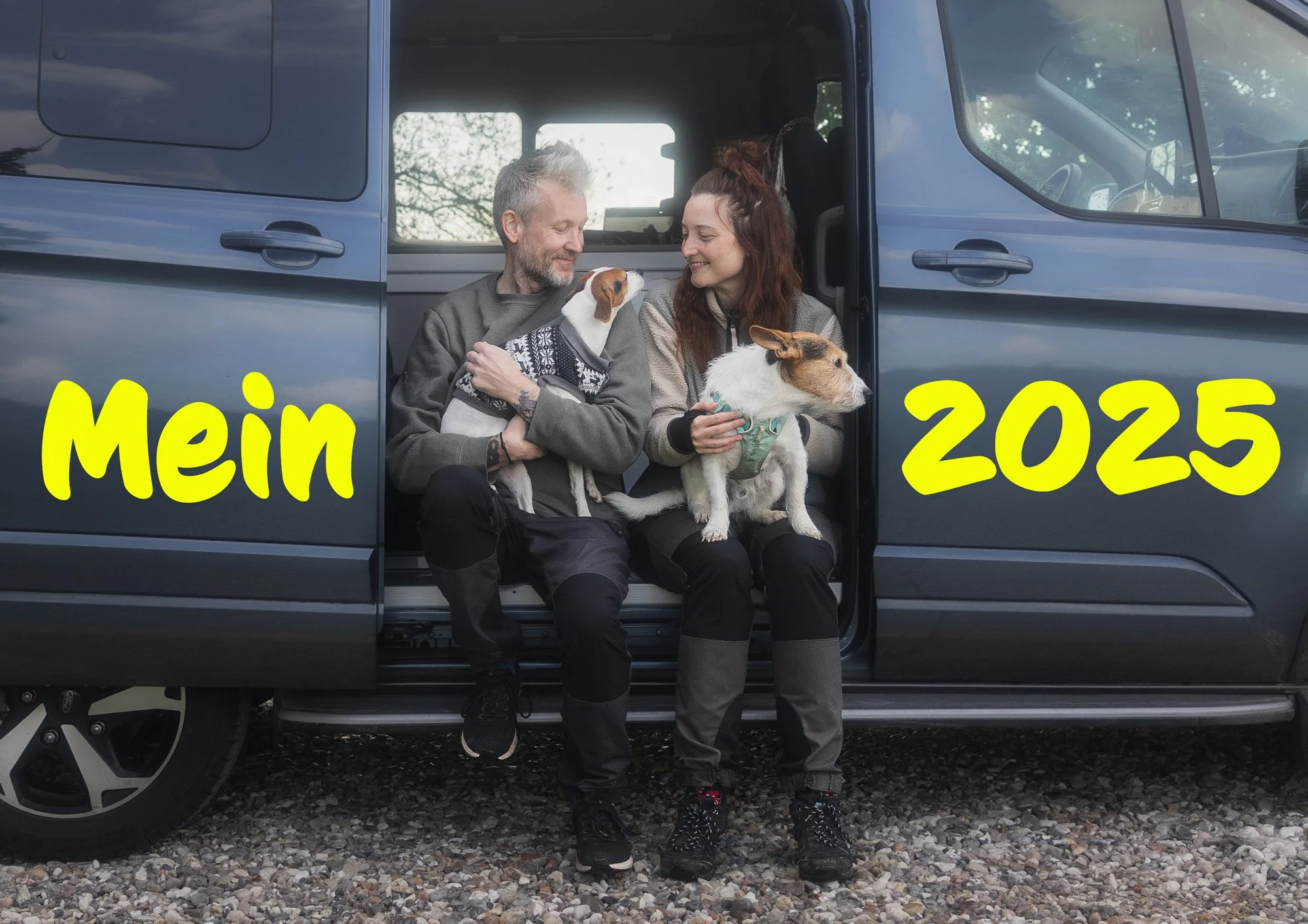 Ein paar sitzt mit ihren Hunden in einem Camper und genießt einen schönen Moment während eines Fotoshootings für Menschen mit Hunden.
