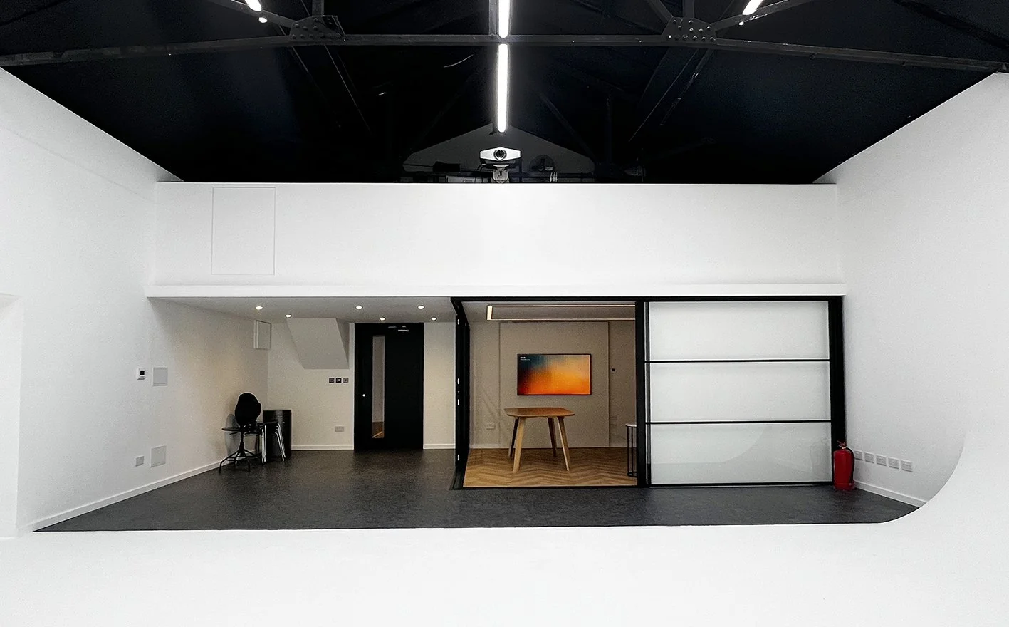 view of the lounge, with its moving glass partition, a projector on top of mezzanine and the entry way to studio B at Shutters Studios