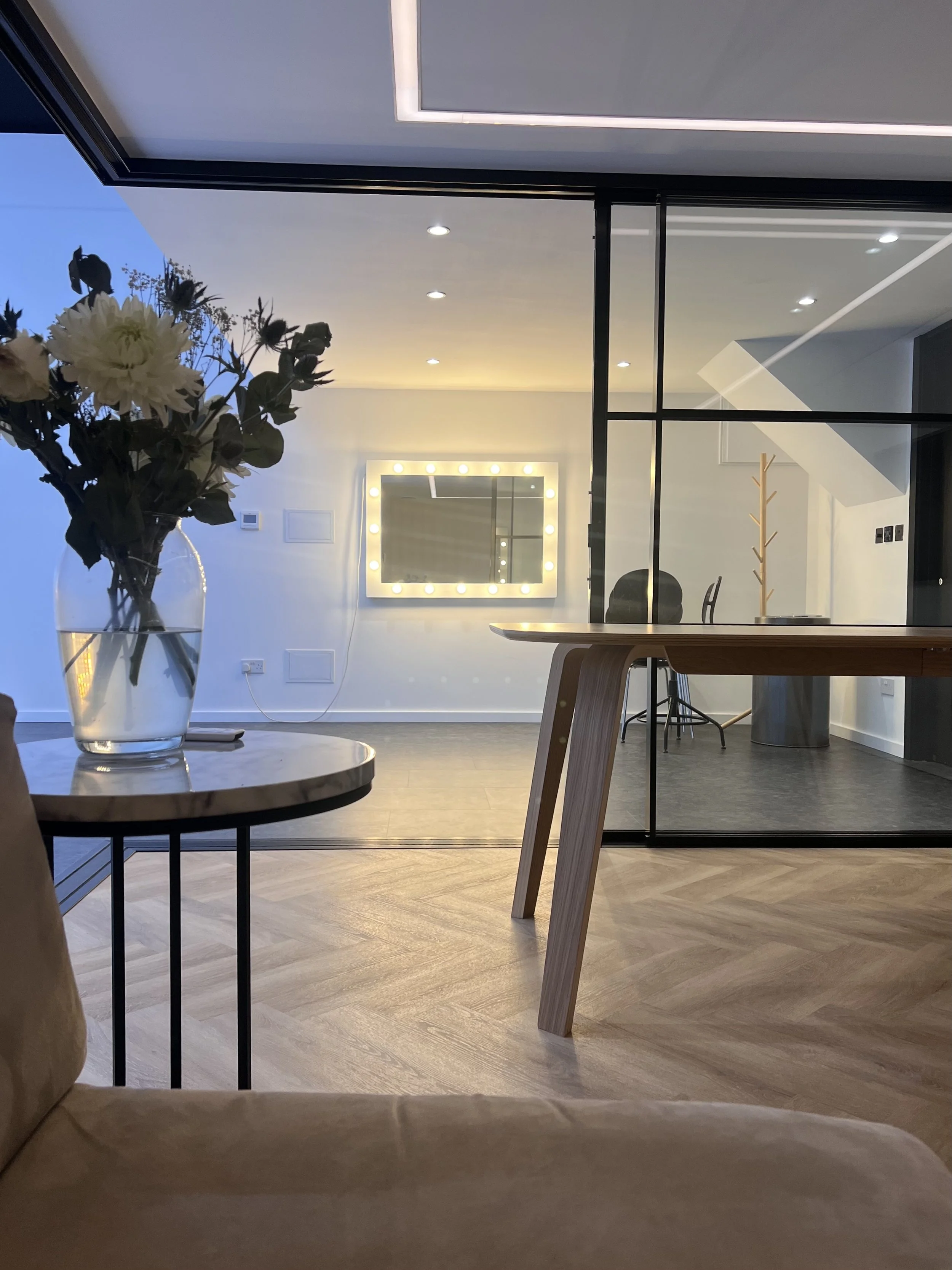 view from tv lounge/podcasting room across the glazed partition and into the makeup area of Studio B at Shutters Studios in Acton, West London W3 7SR