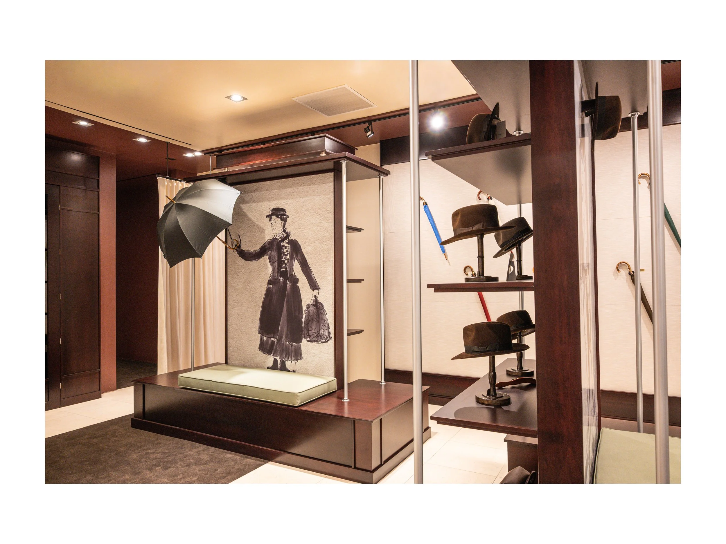 Intérieur de boutique de luxe pièce en cuir à Beverly Hills, Los Angeles, états unis, avec présentoirs en bois foncé et métal, parapluies cuir et bois exotique luxe et accessoires en cuir, éclairage encastré chaleureux lumière douce et chaude et sol 
