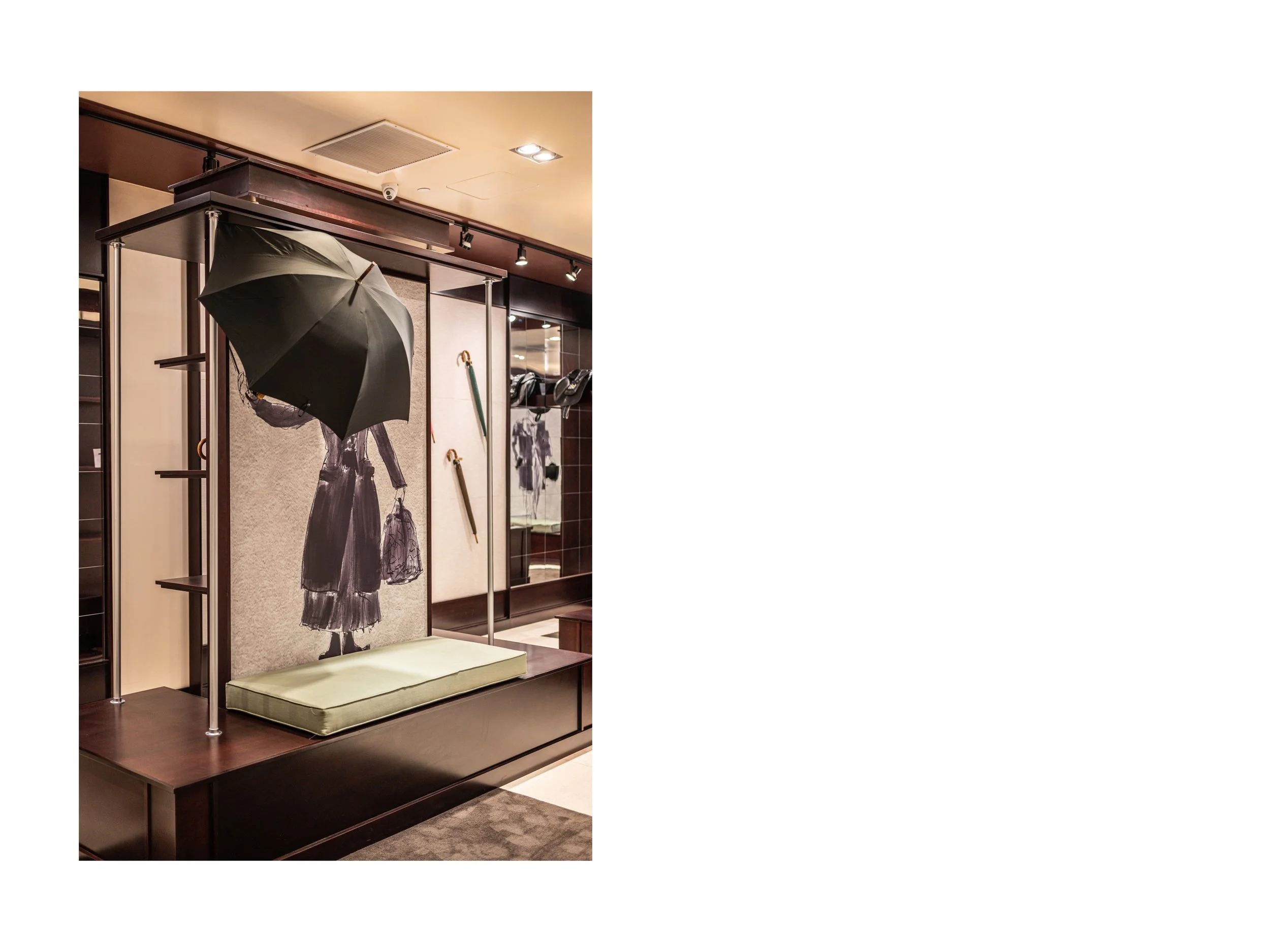 Intérieur de boutique de luxe pièce en cuir à Beverly Hills, Los Angeles, états unis, avec présentoirs en bois foncé et métal, parapluies cuir et bois exotique luxe et accessoires en cuir, éclairage encastré chaleureux lumière douce et chaude et sol 
