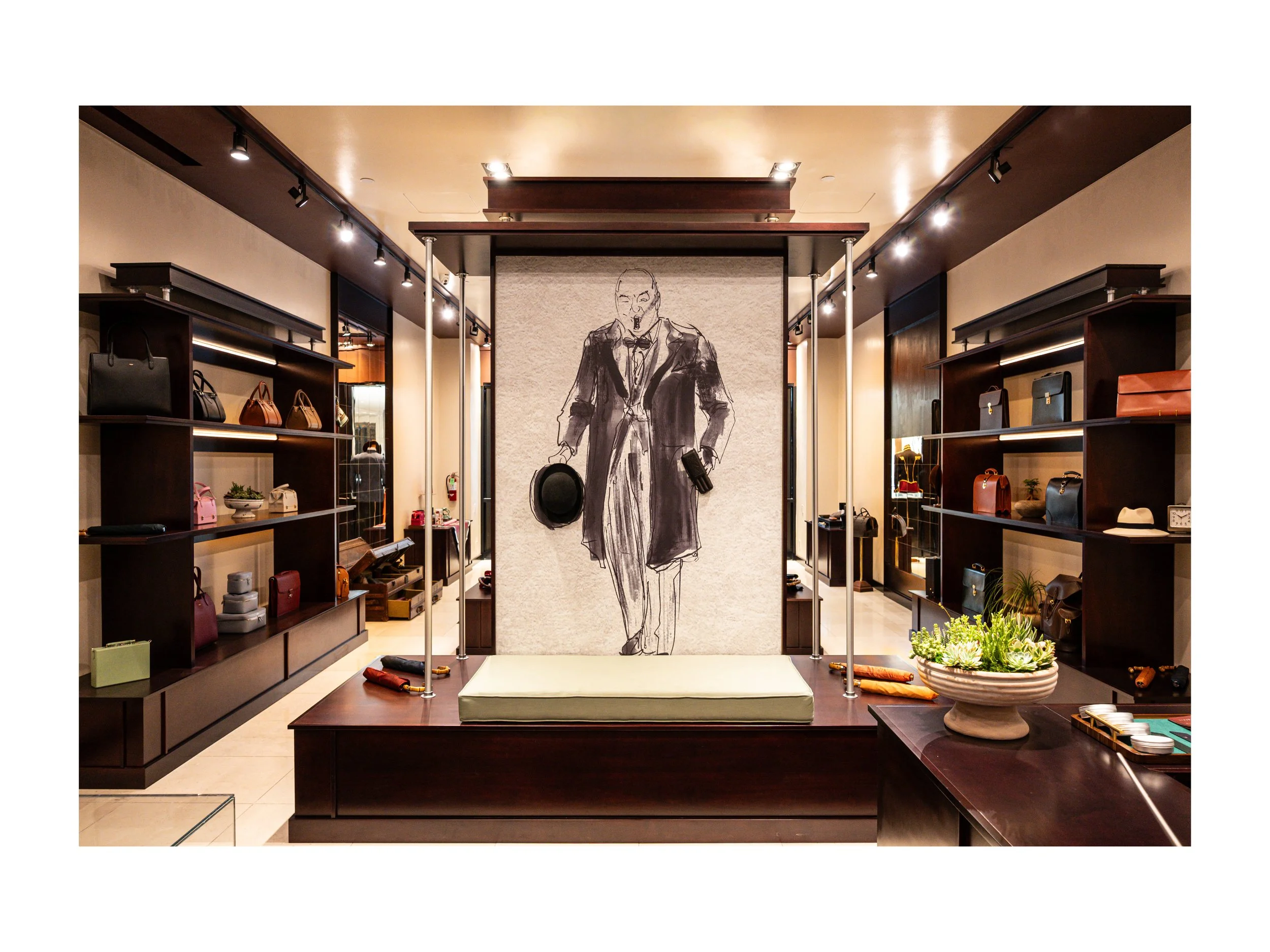 Intérieur de boutique de luxe pièce en cuir à Beverly Hills, Los Angeles, états unis, avec présentoirs en bois foncé et métal, parapluies cuir et bois exotique luxe et accessoires en cuir, éclairage encastré chaleureux lumière douce et chaude et sol