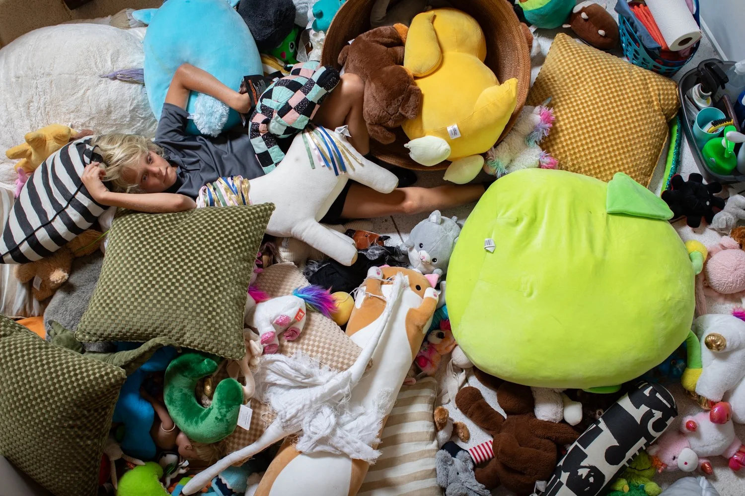 Child surrounded by stuffed animals during a family photography session