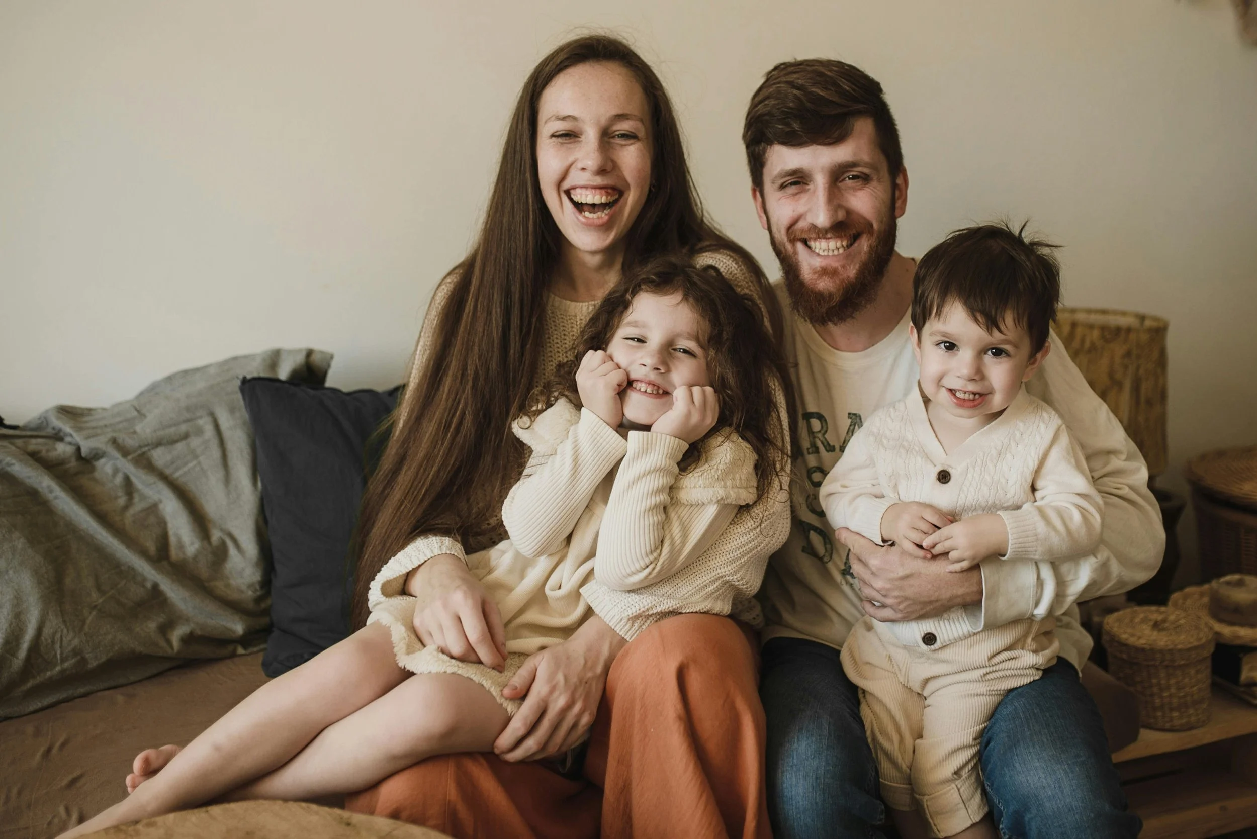 two parents smile while holding two young children