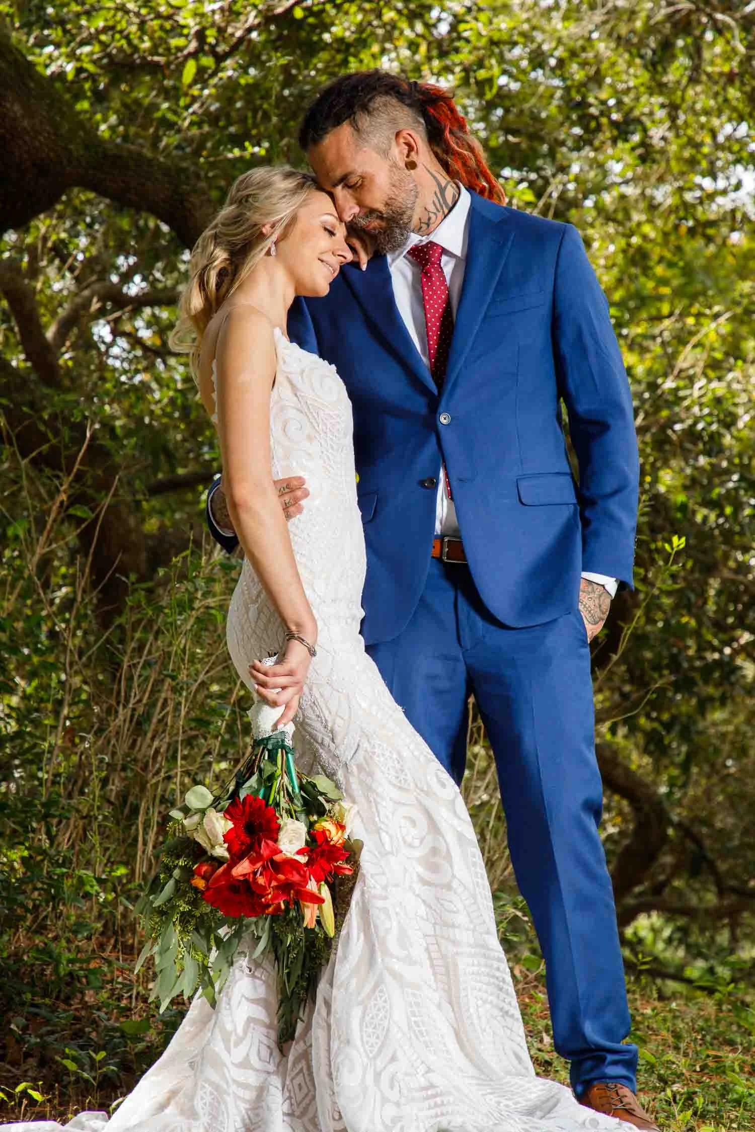 Bride and groom embracing during an outdoor wedding portrait surrounded by natural greenery photographed by a St. Petersburg wedding photographer, JMC Innovations.
