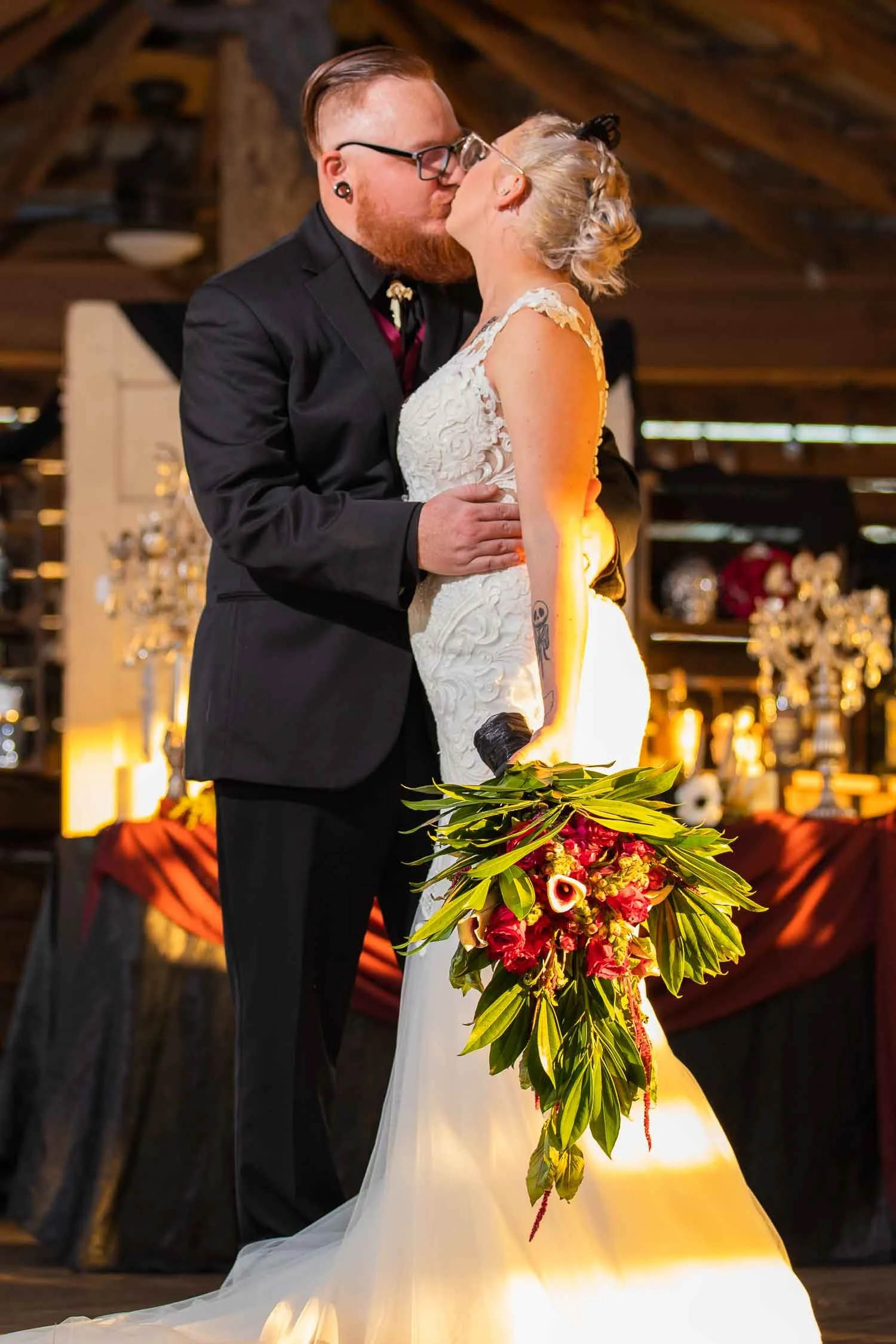 Bride and groom sharing a kiss during an indoor wedding reception photographed by a Seffner wedding photographer, JMC Innovations.