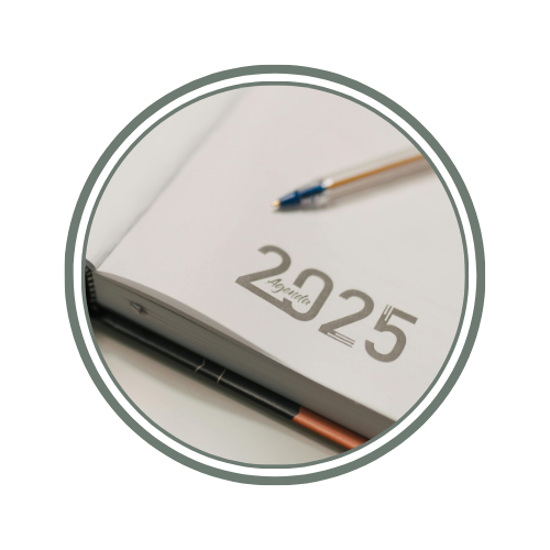 Open planner or calendar showing the year 2025, with a pen resting on the page.