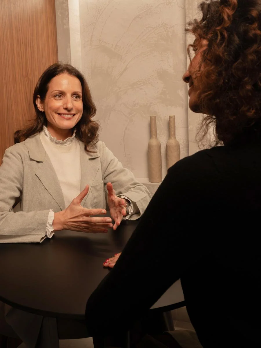 A woman doctor talking to a patient in a warm wooden room