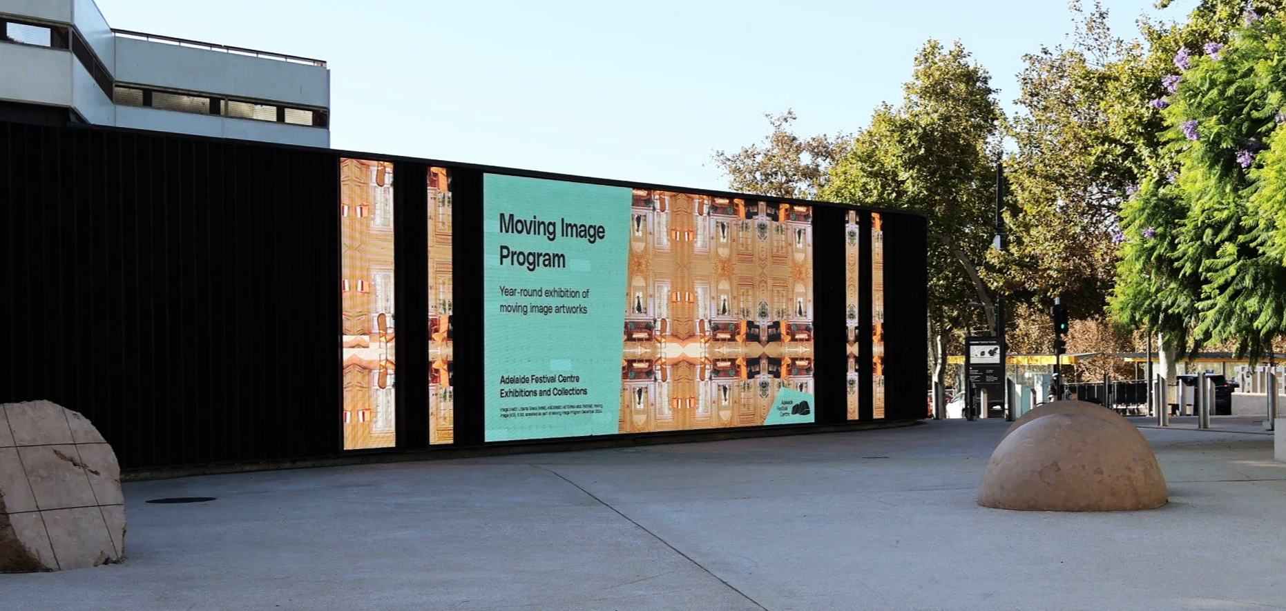 Outdoor digital billboard displaying information about the 'Moving Image Program,' an exhibition of moving image artworks at the Adelaide Festival Centre.