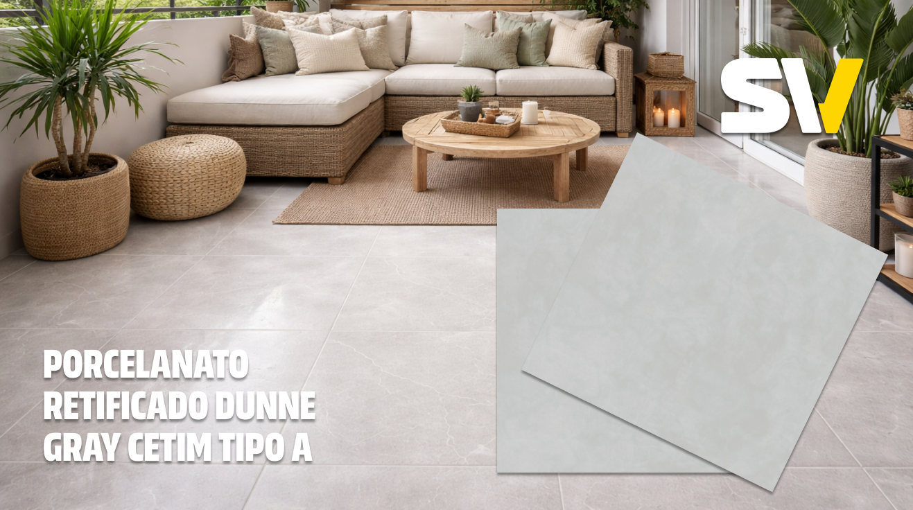 Interior de uma sala de estar com piso de porcelanato retificado Dunne Gray Cetim, sofá branco com almofadas, mesa de centro de madeira, plantas em vasos de cerâmica, e iluminação suave com velas.