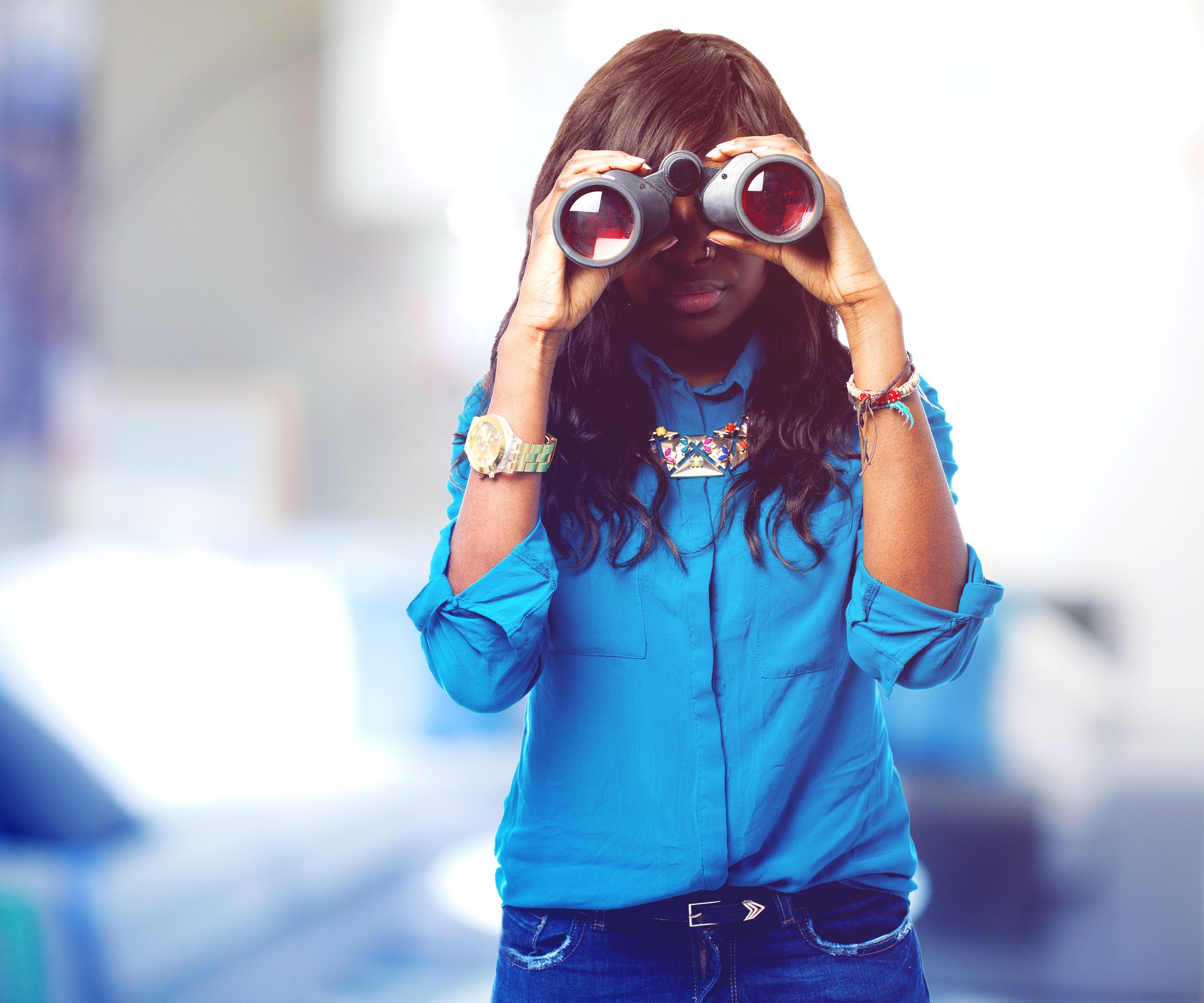 A black woman using her binoculars