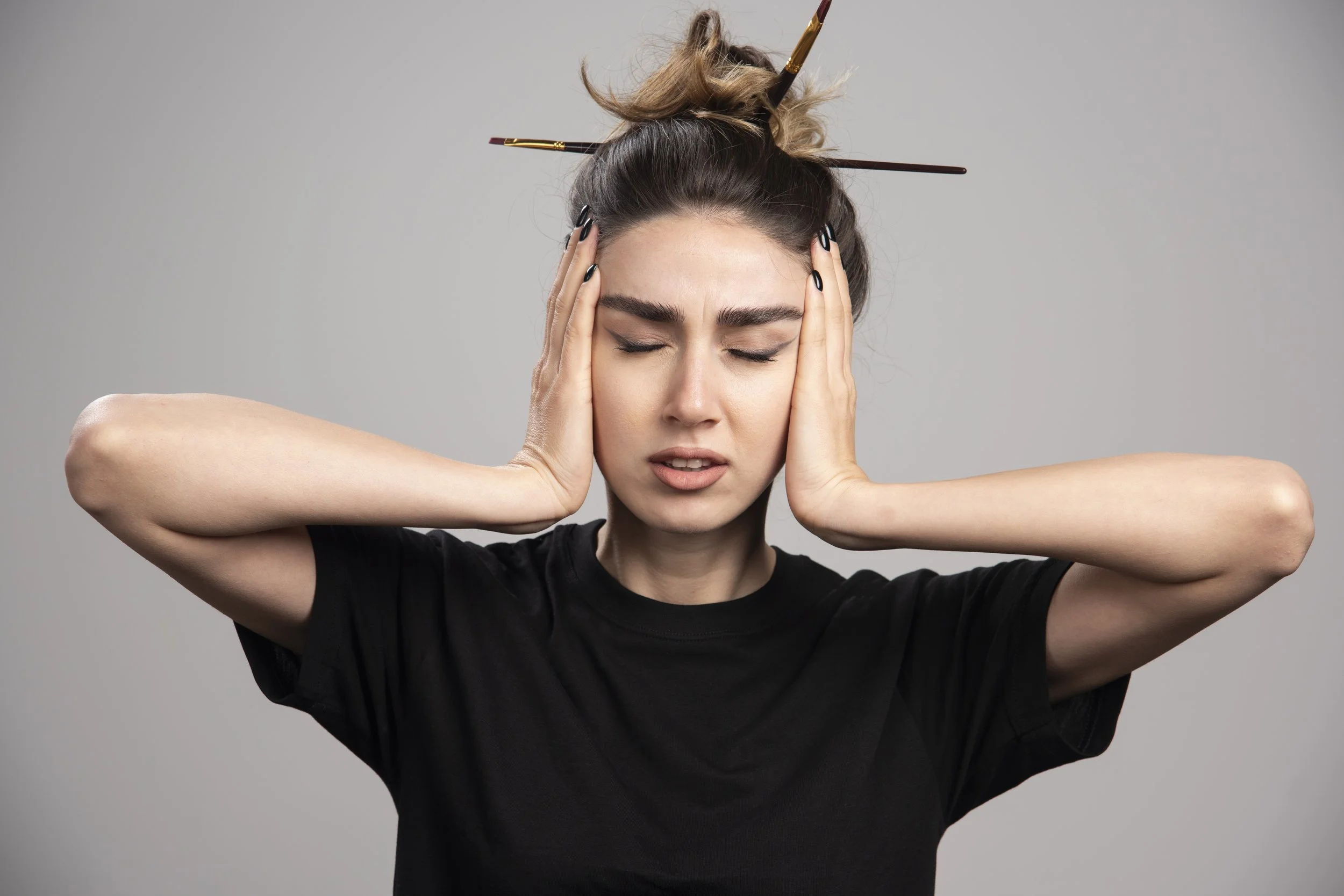 A young woman with her hands on her head