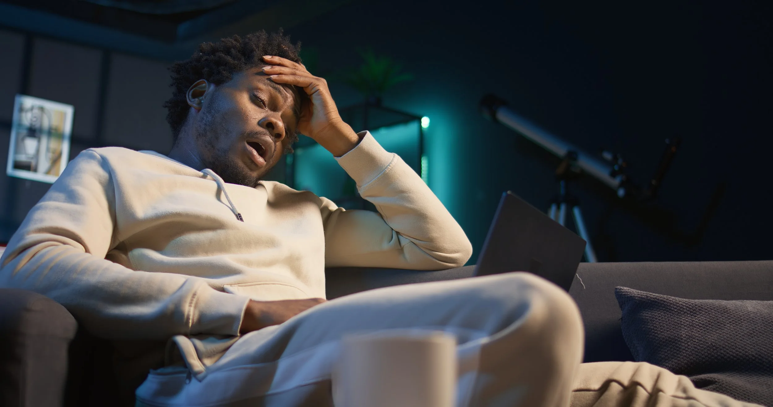 A black man on a couch drained