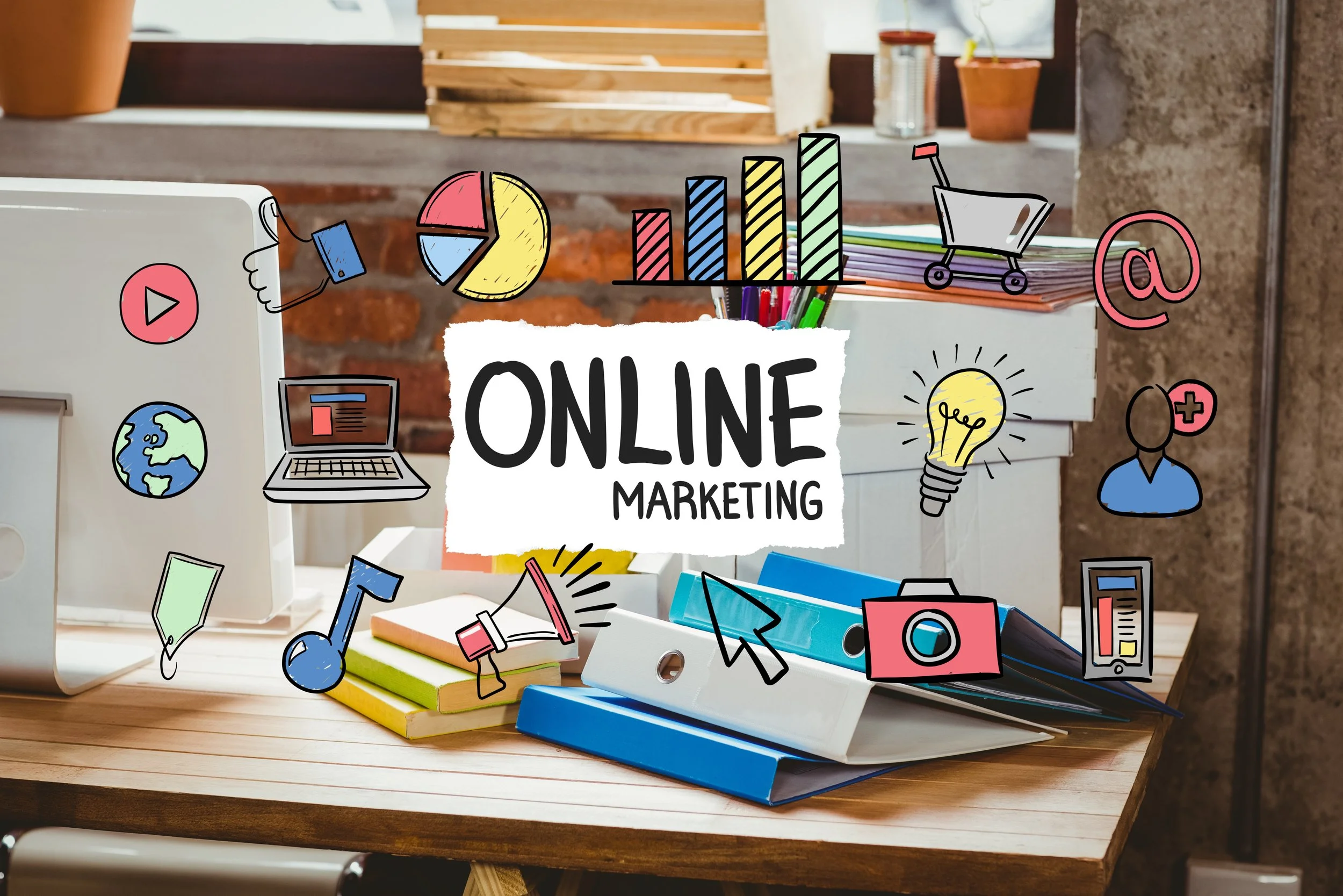 Online marketing concept shown on a desk with binders, books, and a computer, overlaid with colorful icons like charts, email, shopping cart, and social media symbols surrounding the words Online Marketing