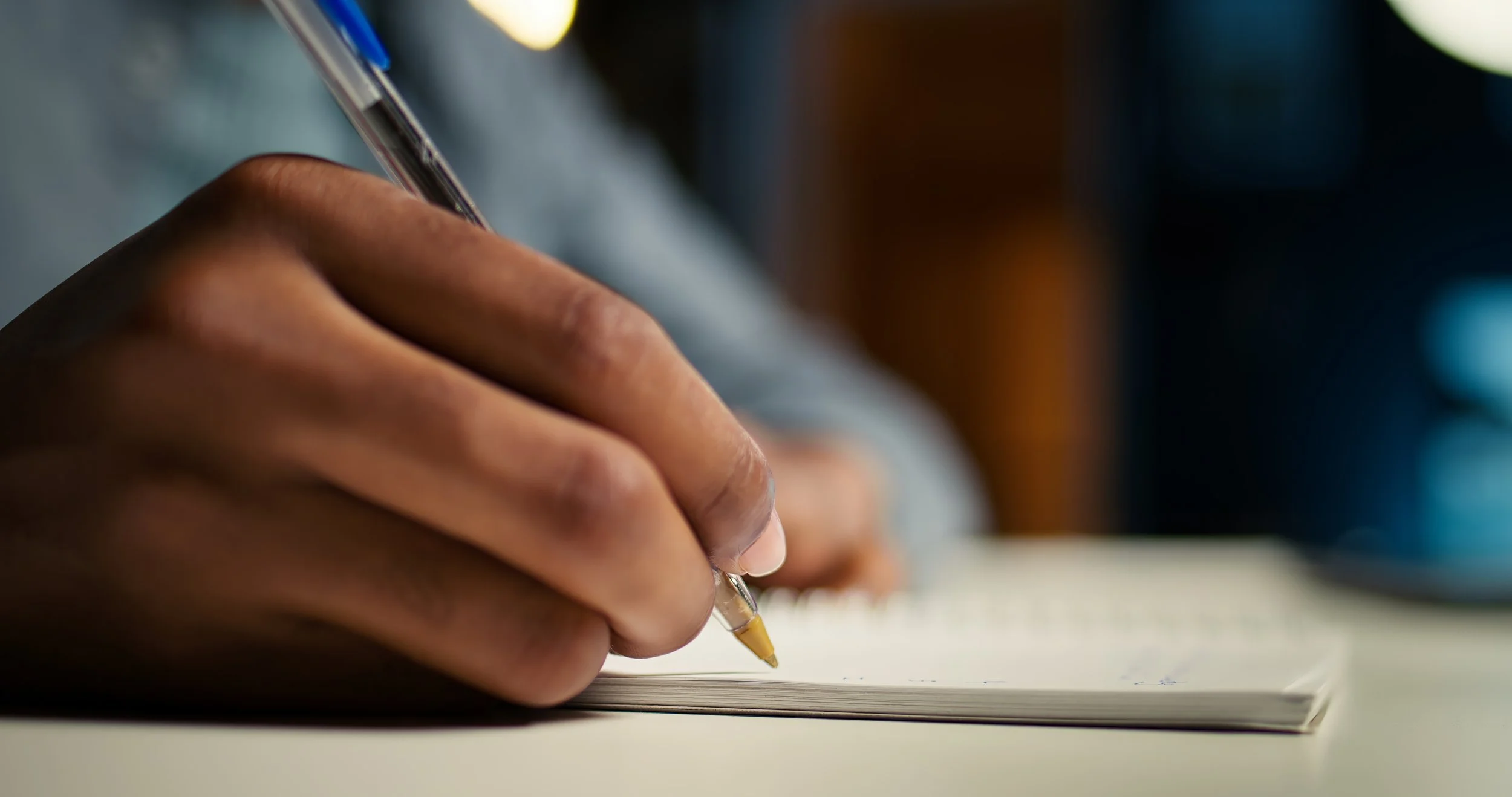 black person writing on a notepad