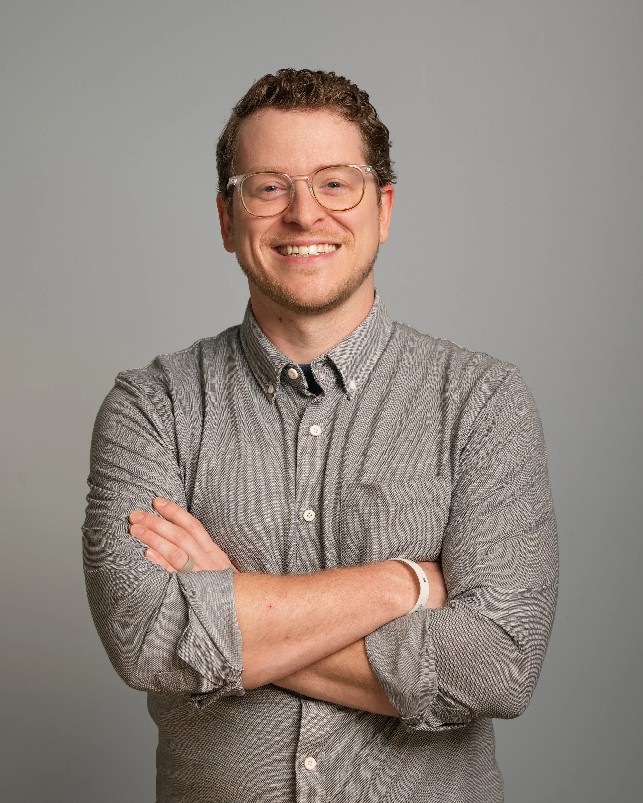 MAN WITH CROSSED ARMS POSING FOR A HEADSHOT