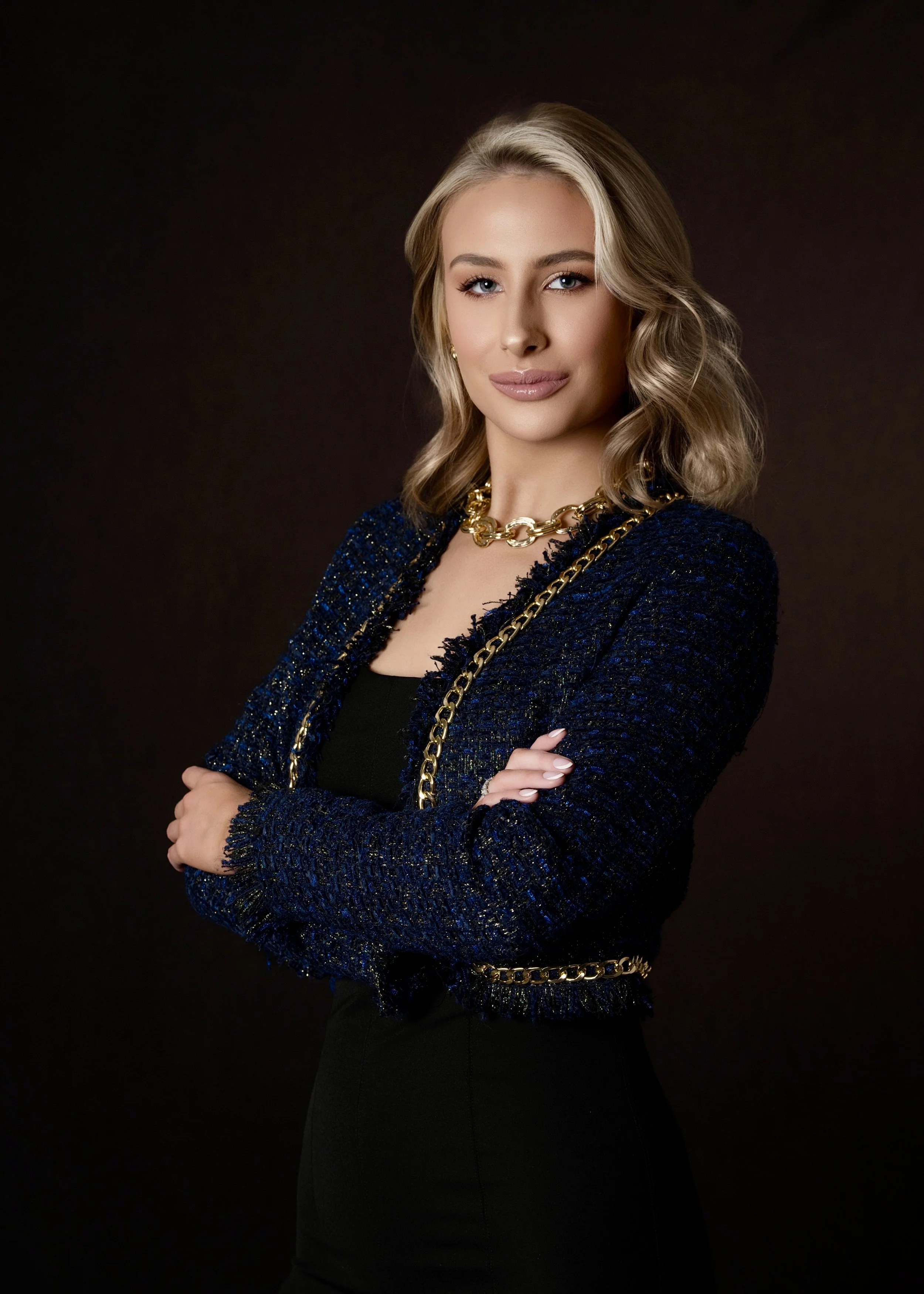 WOMAN STANDING WITH CROSSED ARMS IN A LEADERSHIP POSITION