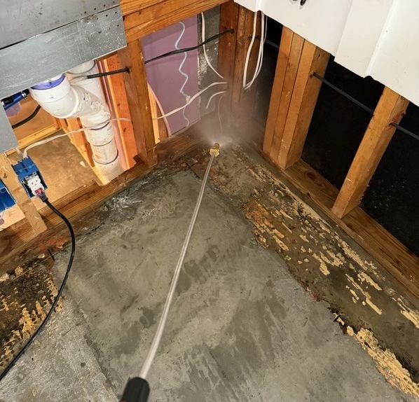 Antimicrobial application on exposed wood and concrete after a sewage damage event in a home.