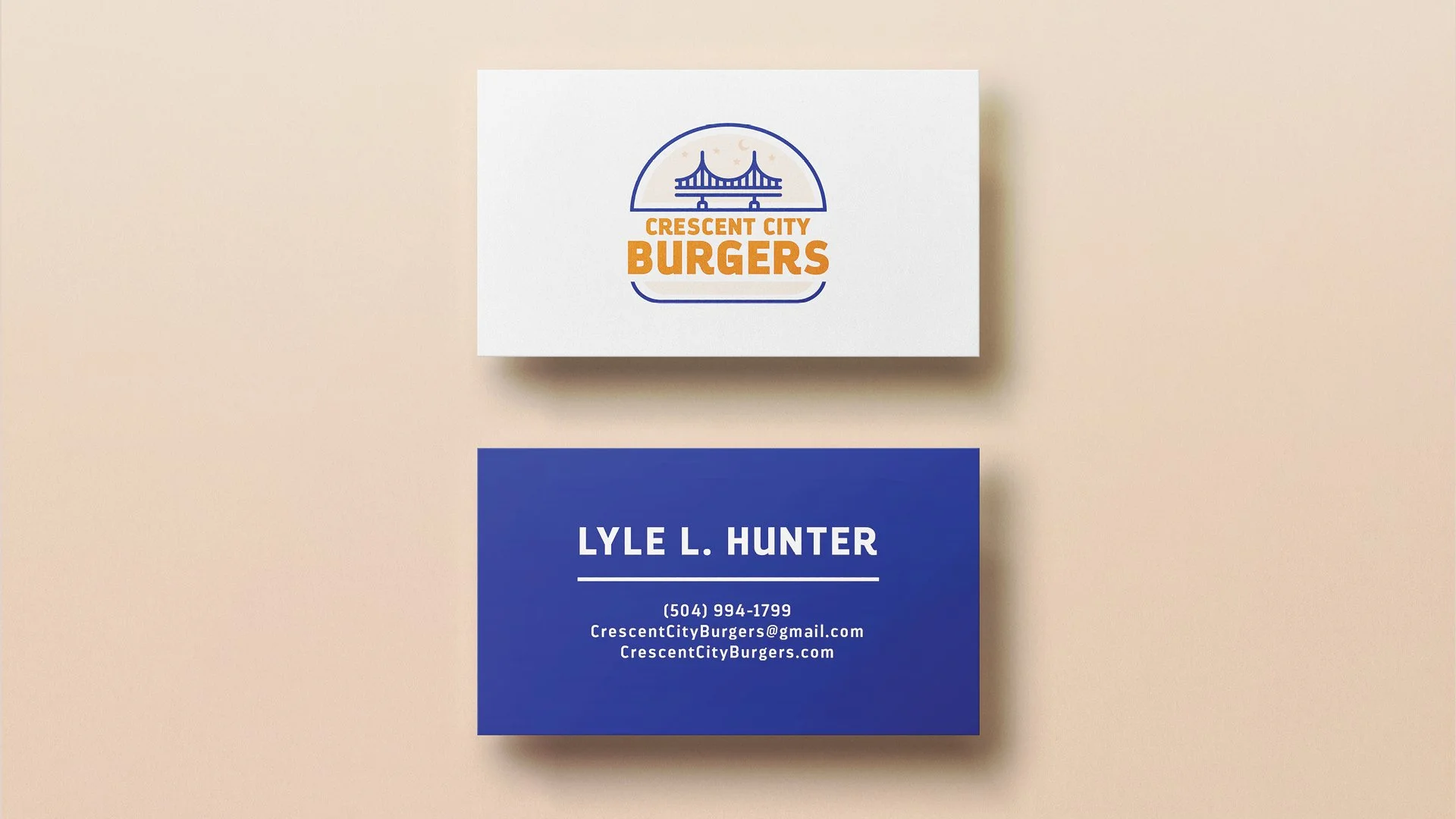 Business card with a navy blue background displaying the name Lyle L. Hunter, phone number, email, and website for Crescent City Burgers. The other card, above, has a logo with a bridge and the text Crescent City Burgers in orange.