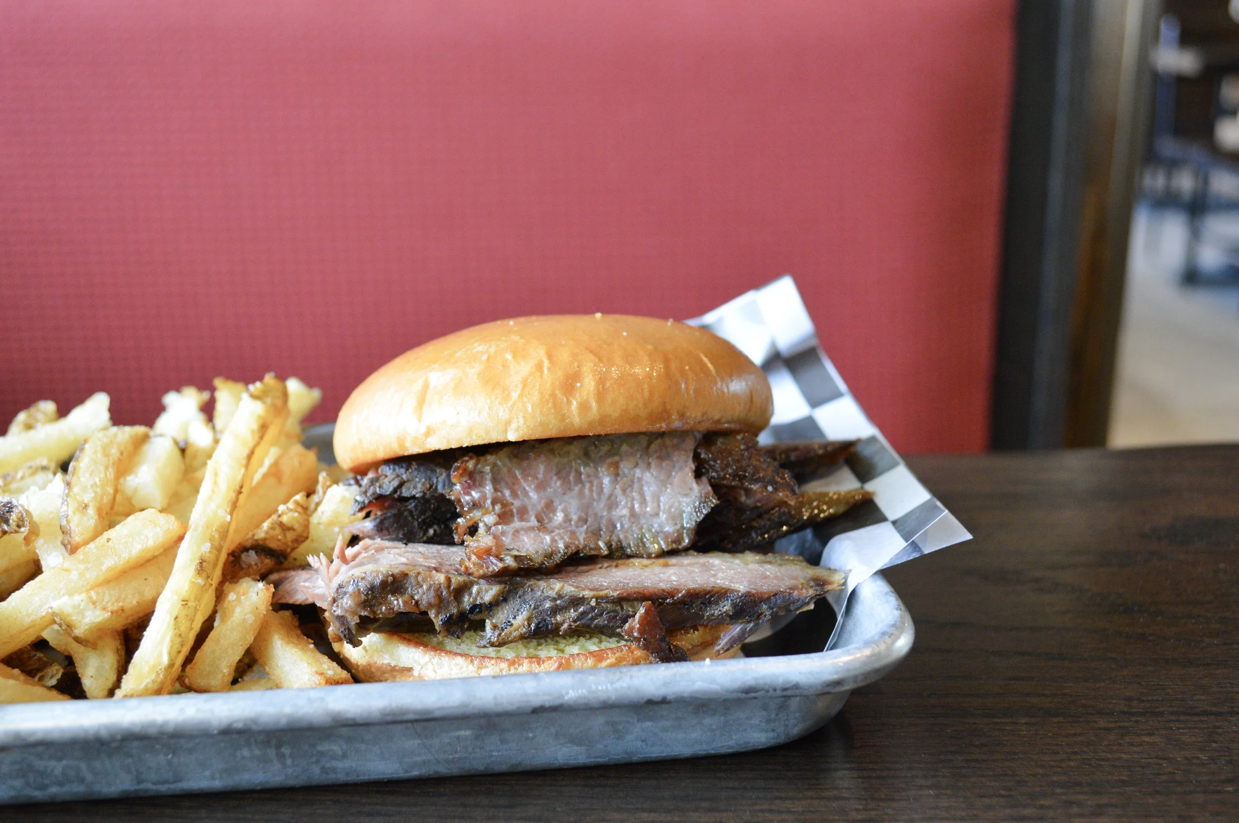 smoked brisket sandwich with side of fries