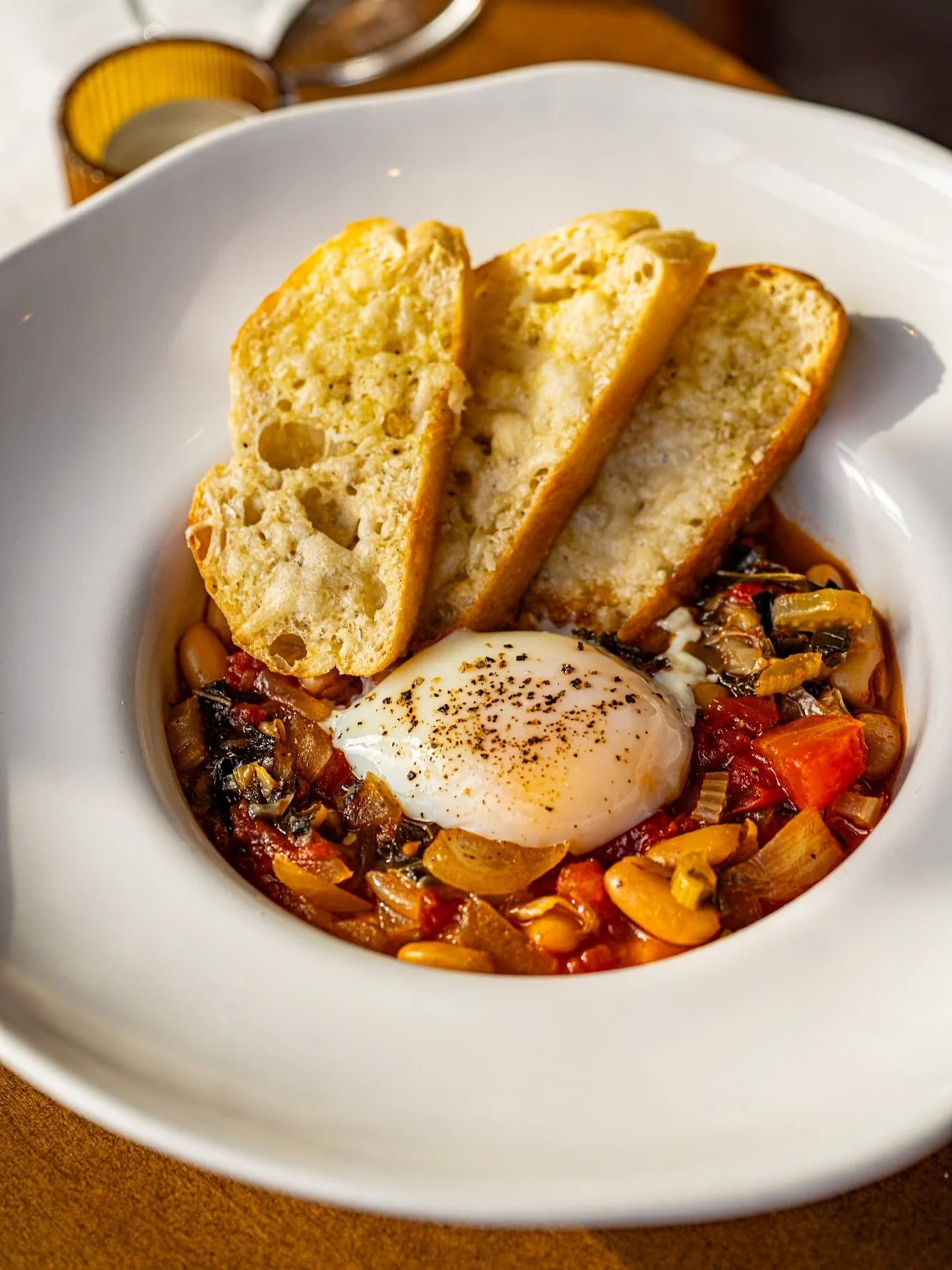 Rustic comfort for a chilly, rainy day 🍲 Tuscan Peasant Soup with cabbage, cannellini beans, 64-degree egg, tomatoes, day-old bread &amp; Parmigiano Reggiano.