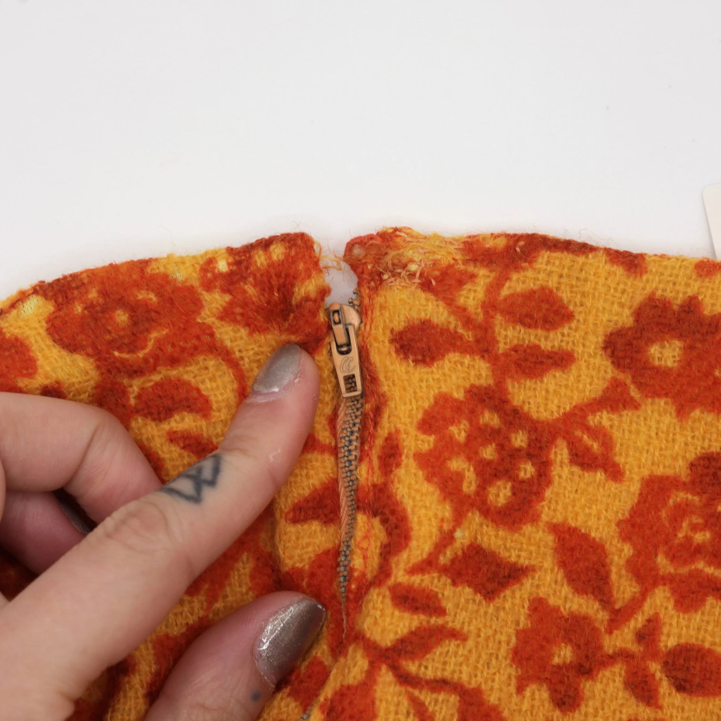 Ejemplo de un cierre metálico vintage encontrado en un vestido de los 1960s. Los cierres metálicos se pueden encontrar en vestidos de los 1960s y anteriores. También hay cierres metálicos en algunos vestidos modernos, pero tienen un estilo diferente.