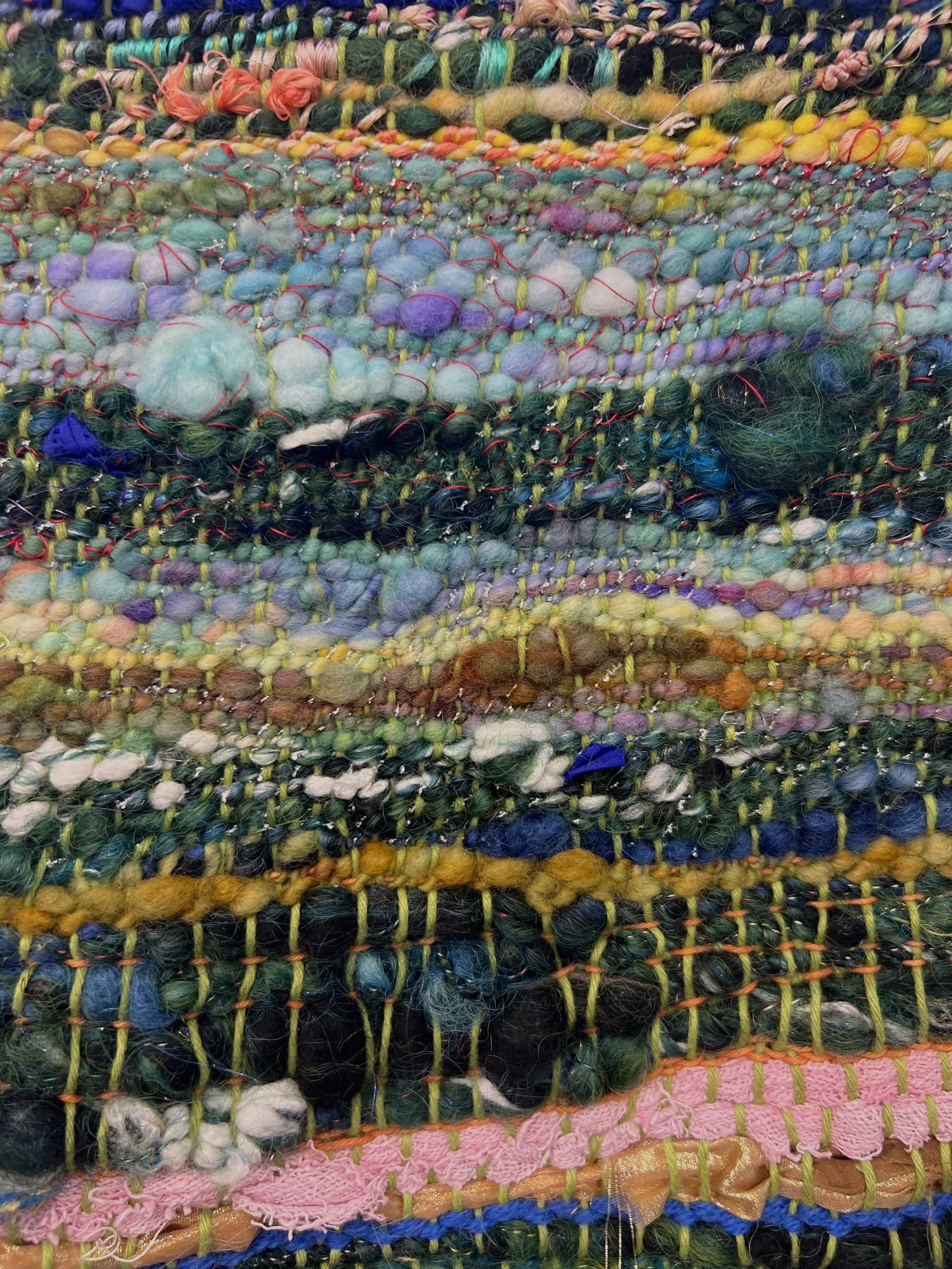 Colorful woven textile with various textures and yarns.