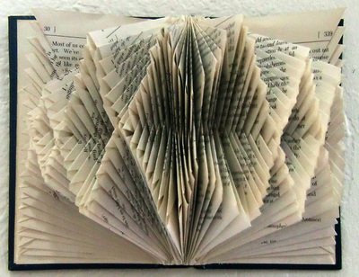 Rescued old book with pages folded creating an abstract repeating pattern.