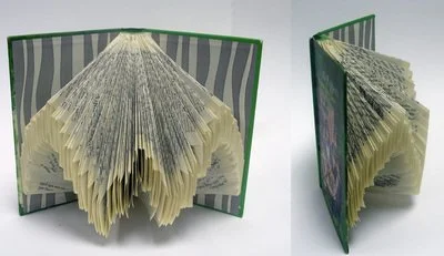 Rescued old book with pages folded creating an abstract repeating pattern.