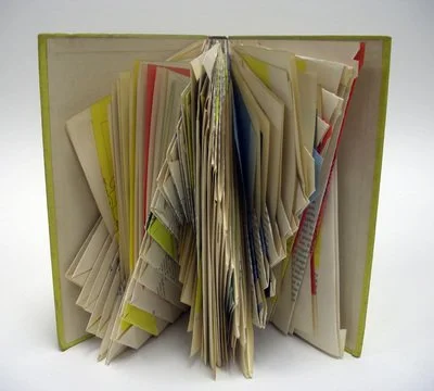 Rescued old book with pages folded creating an abstract repeating pattern.