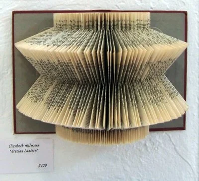 Rescued old book with pages folded creating an abstract repeating pattern.