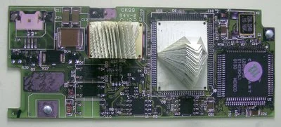 Close-up of a green electronic circuit board with a central heat sink, an Ethernet port, various chips, and other small electronic components. with Rescued old book with pages folded creating an abstract repeating pattern on the circuit board