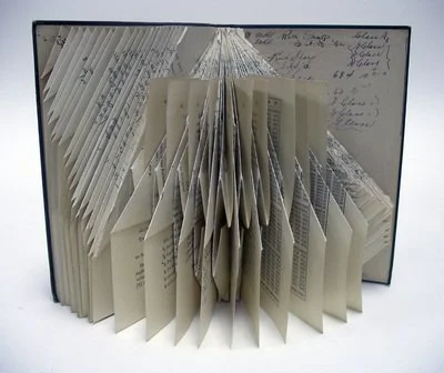 Rescued old book with pages folded creating an abstract repeating pattern.