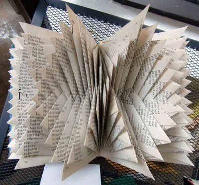 Rescued old book with pages folded creating an abstract repeating pattern.