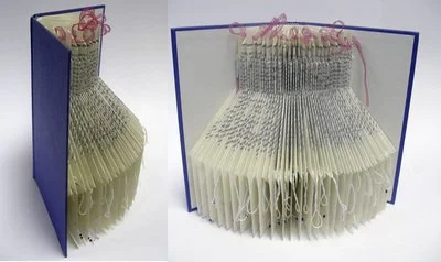 Rescued old book with pages folded creating an abstract repeating pattern with silk ribbon